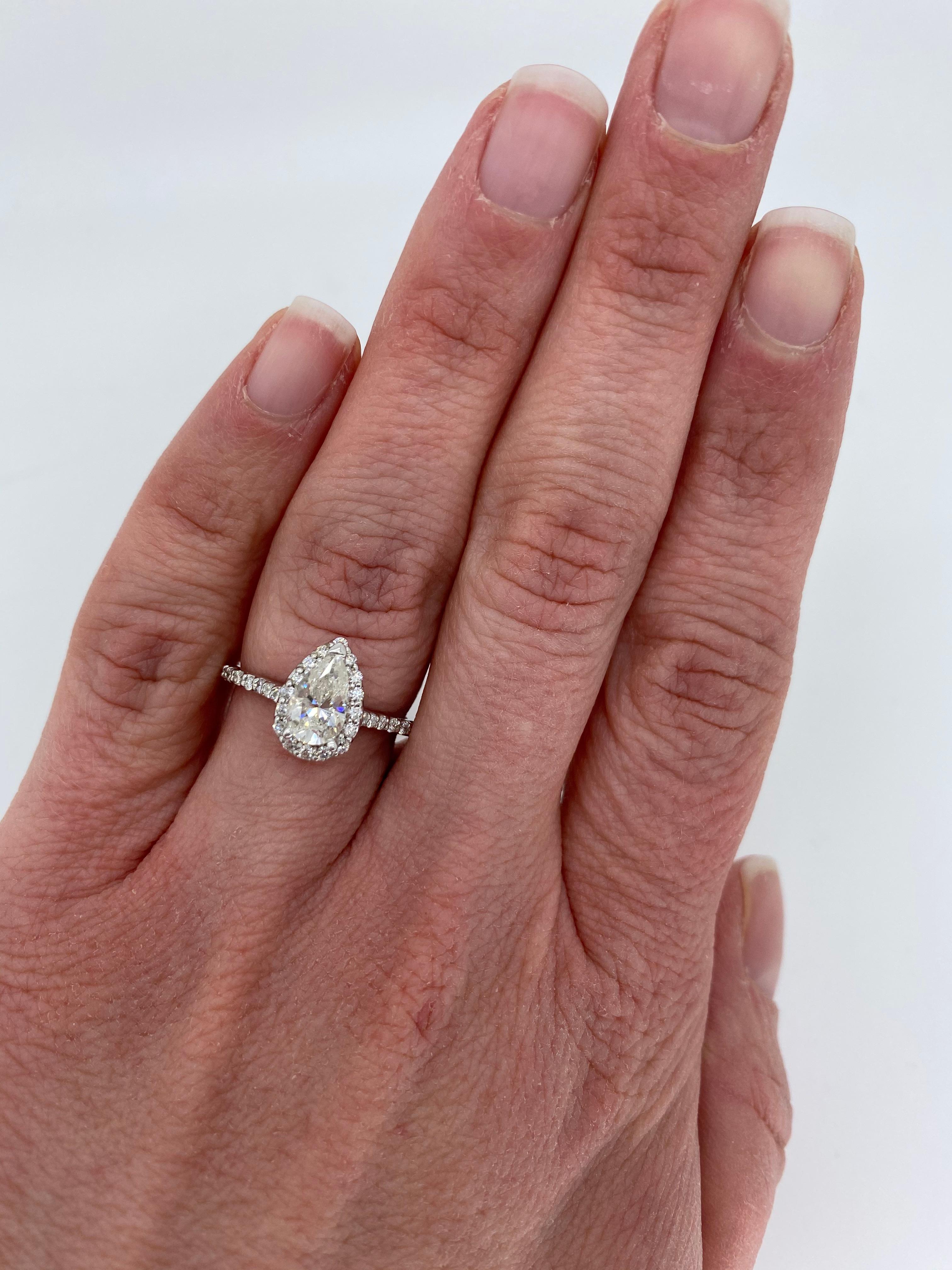 Pear shaped halo diamond ring crafted in 14k white gold. 

Center Diamond Carat Weight: Approximately .92CT
Center Diamond Cut: Pear Cut
Center Diamond Color: J
Center Diamond Clarity: I1
Total Diamond Carat Weight: Approximately 1.24CTW
Accent