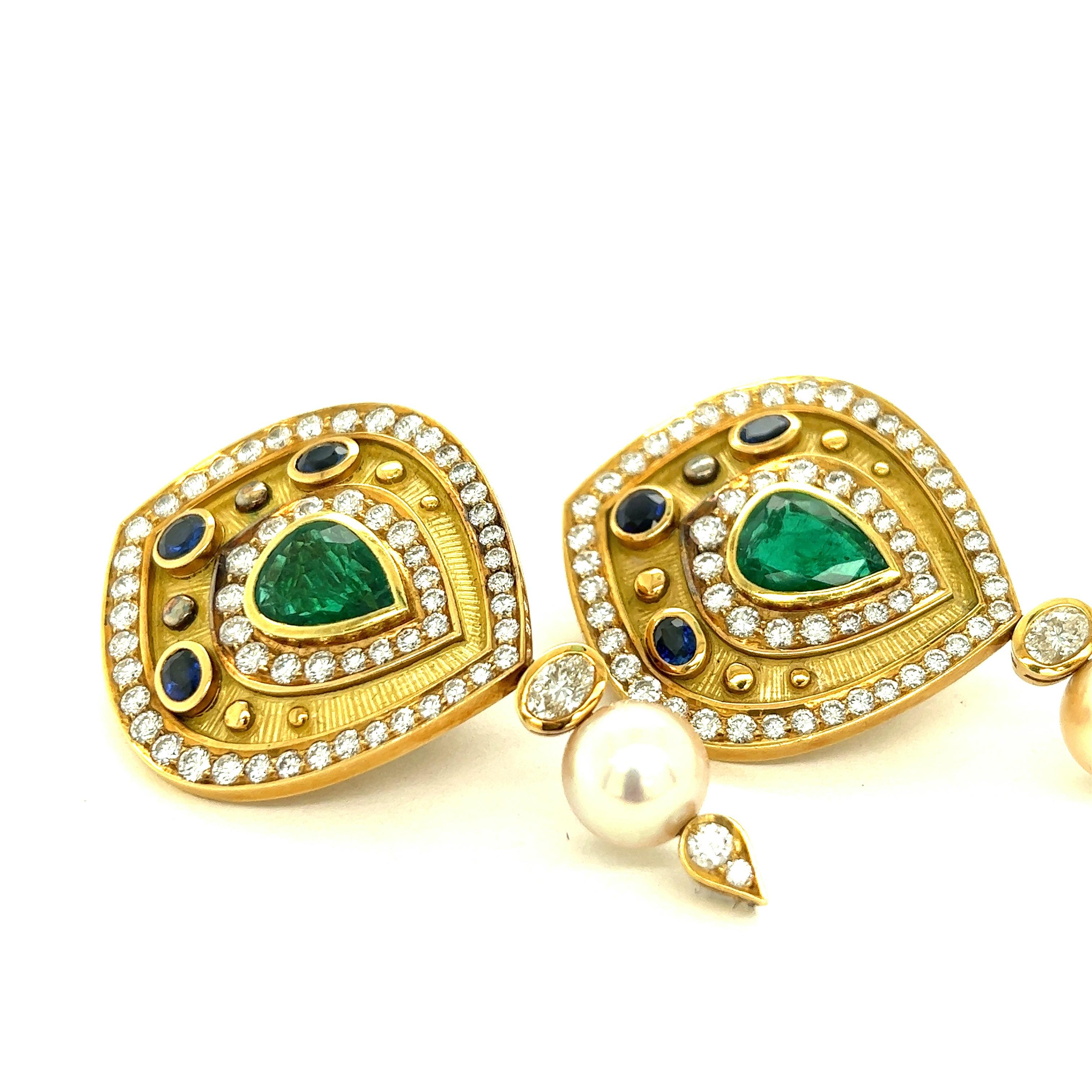Pear Shaped Emerald, Diamond, and Sapphire 18k Yellow Gold Earrings

Bezel-set pear-shaped emeralds of approximately 7.5 carats total; round, brilliant-cut and oval diamonds of approximately 12 carats total; round and oval cut sapphires of