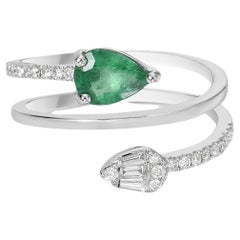 Anillo en espiral con esmeralda y diamantes en forma de pera, acentuado con diamantes en pavé