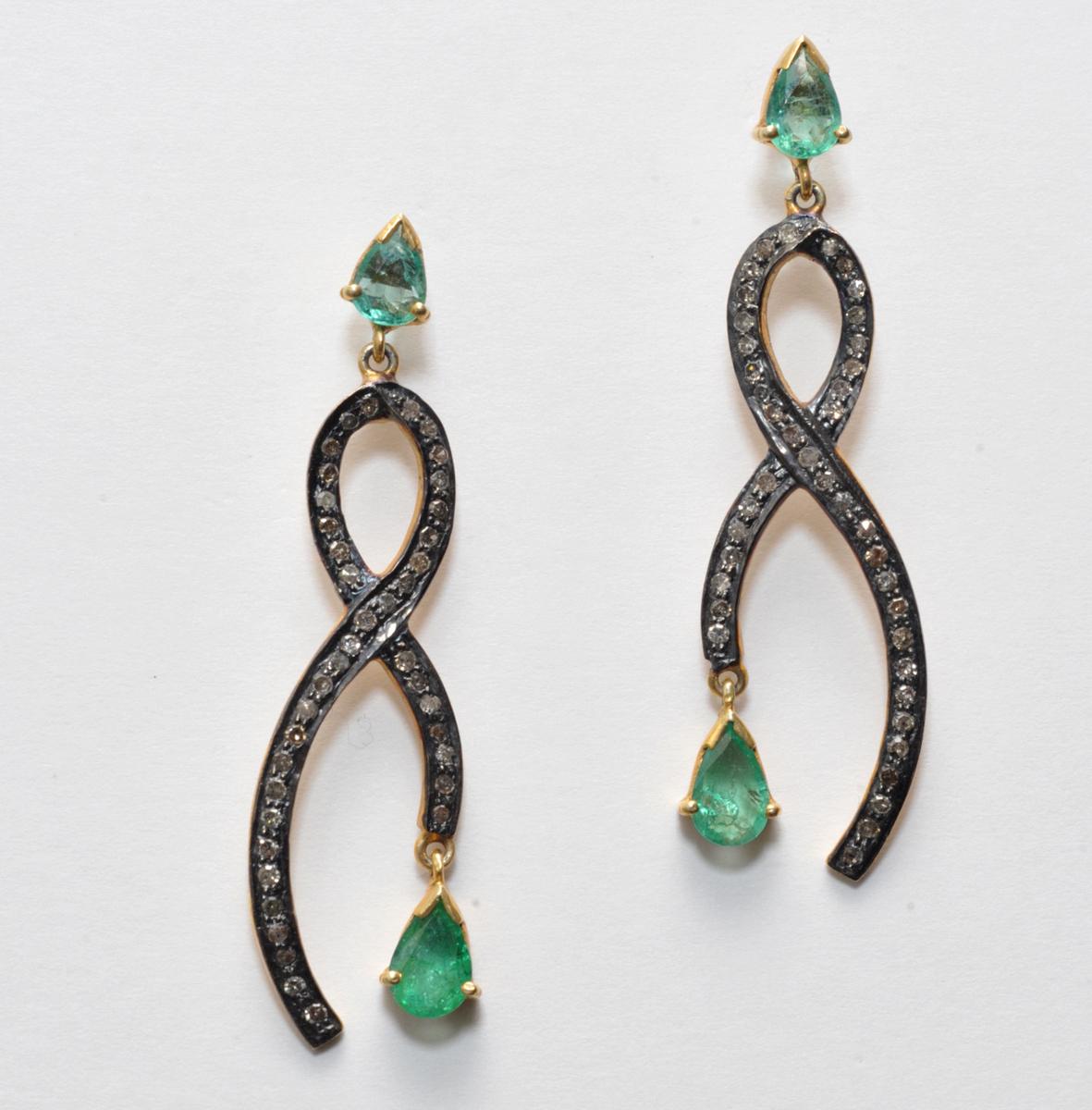Pair of earrings with pear-shaped faceted emeralds set in 18K gold on the post and dangle.  The body of the earrings are pave`set diamonds in oxidized sterling.