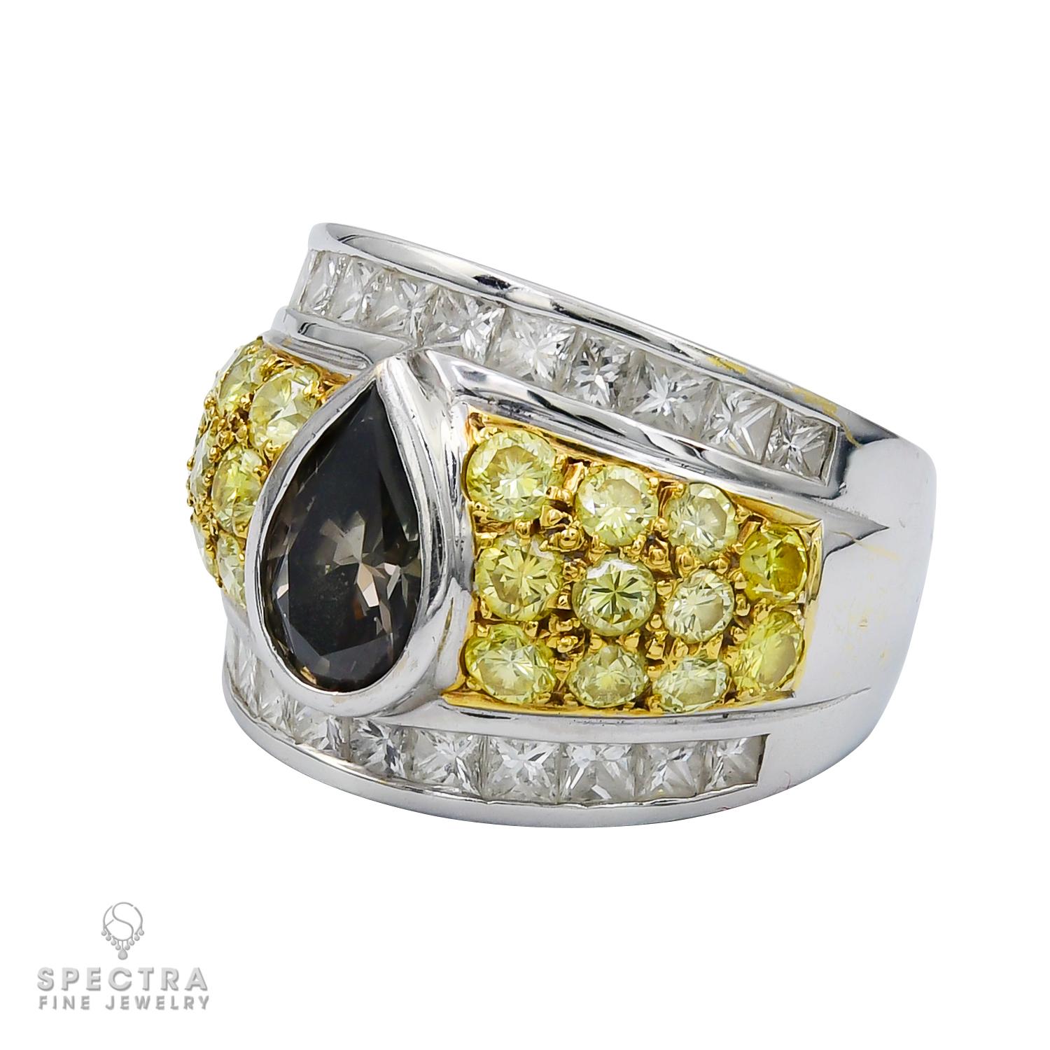 Este llamativo anillo de cóctel presentado por Spectra Fine Jewelry es una celebración de atrevidos contrastes y refinada elegancia. En su corazón yace un cautivador diamante gris verdoso fantasía en forma de pera de 1,80 quilates, que irradia un
