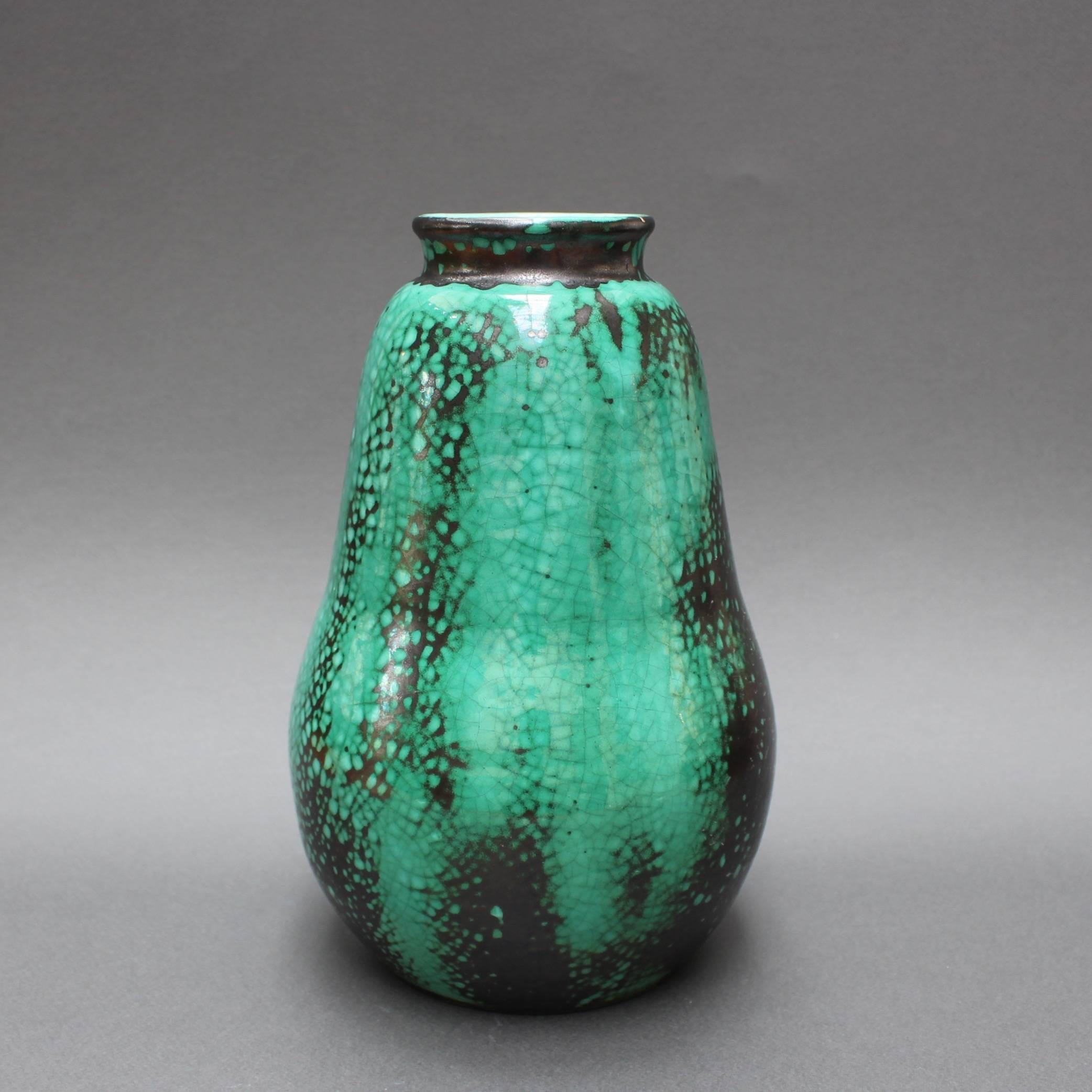 Pear-shaped, black and green crackle-glazed ceramic Primavera vase by C.A.B. (Céramique d’art de Bordeaux) for Printemps (circa 1930s). The sensuously curved vase effortlessly becomes the focal point of any room's décor. The green colored base is