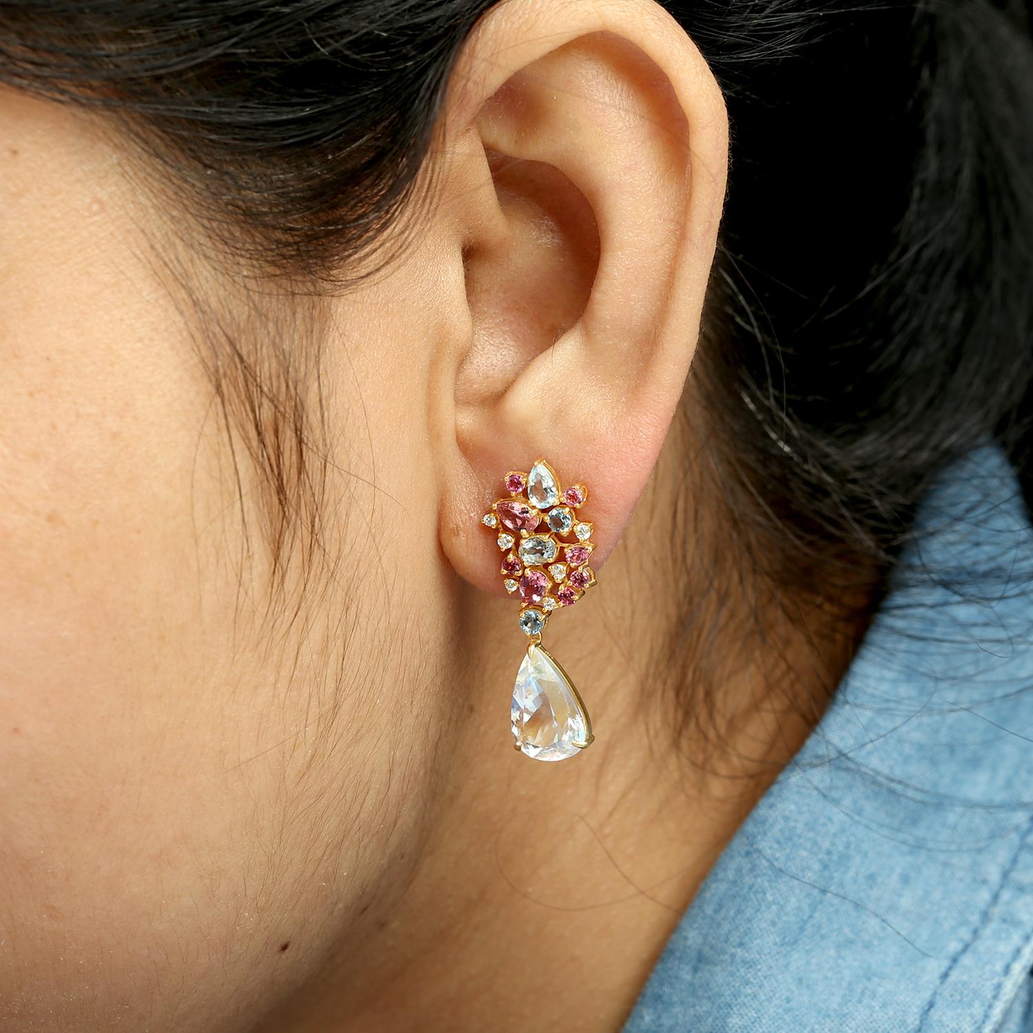 Designed to capture soft iridescence and vibrant color, these dangle earrings feature pear-shaped moonstones paired with multi-colored tourmalines and accent diamonds. Crafted in 14k gold, the lightweight 33x13 mm silhouette showcases 6.89 carats of