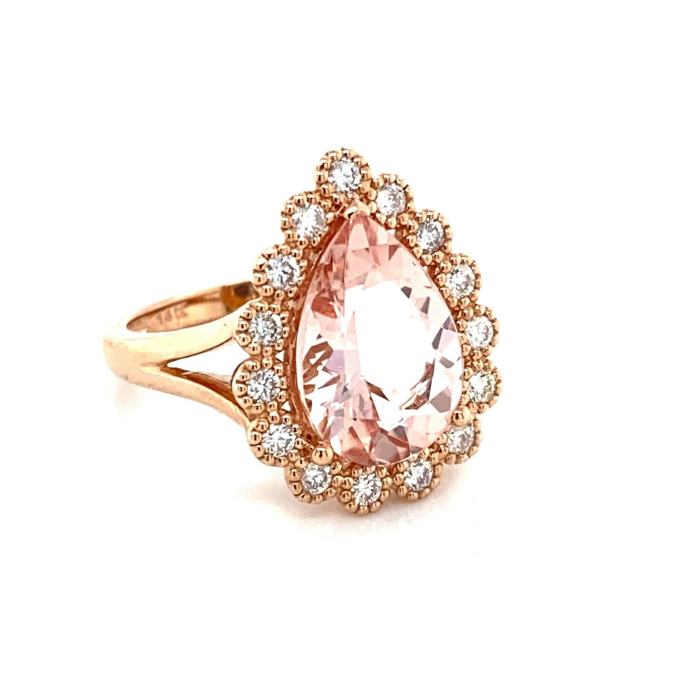 This is an exquisite pear shaped natural 3.85CT morganite and diamond ring set in solid 14K rose gold. This ring features a stunning natural 14x10MM pear cut morganite stone with excellent peachy pink color (AAA quality gem) and is surrounded by a