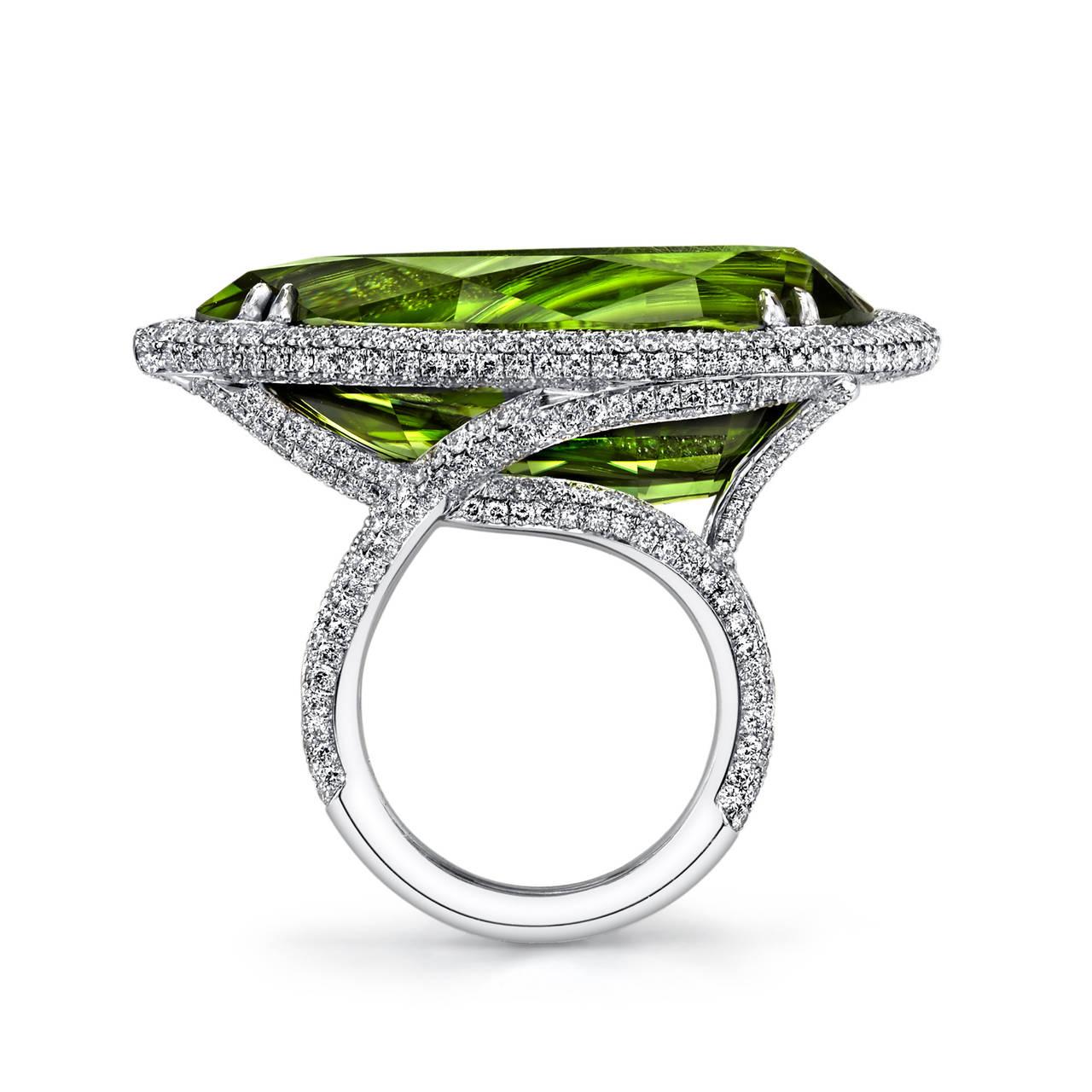 This exquisite Pear-Shaped Pakistani Peridot ring set in 18 Karat White Gold is the epitome of elegance and sophistication. Accented with Micro Pave Ideal Cut White Diamonds, the ring boasts a GIA Certified Center Stone with a total weight of
