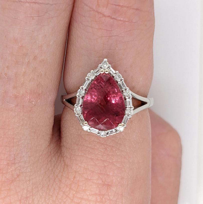 This stunning ring features a beautiful rubellite pink tourmaline framed by a mixed round and baguette diamond halo and a split shank. A beautiful collection piece that is perfect for every occasion. 💕

**We offer complimentary resizing, message us