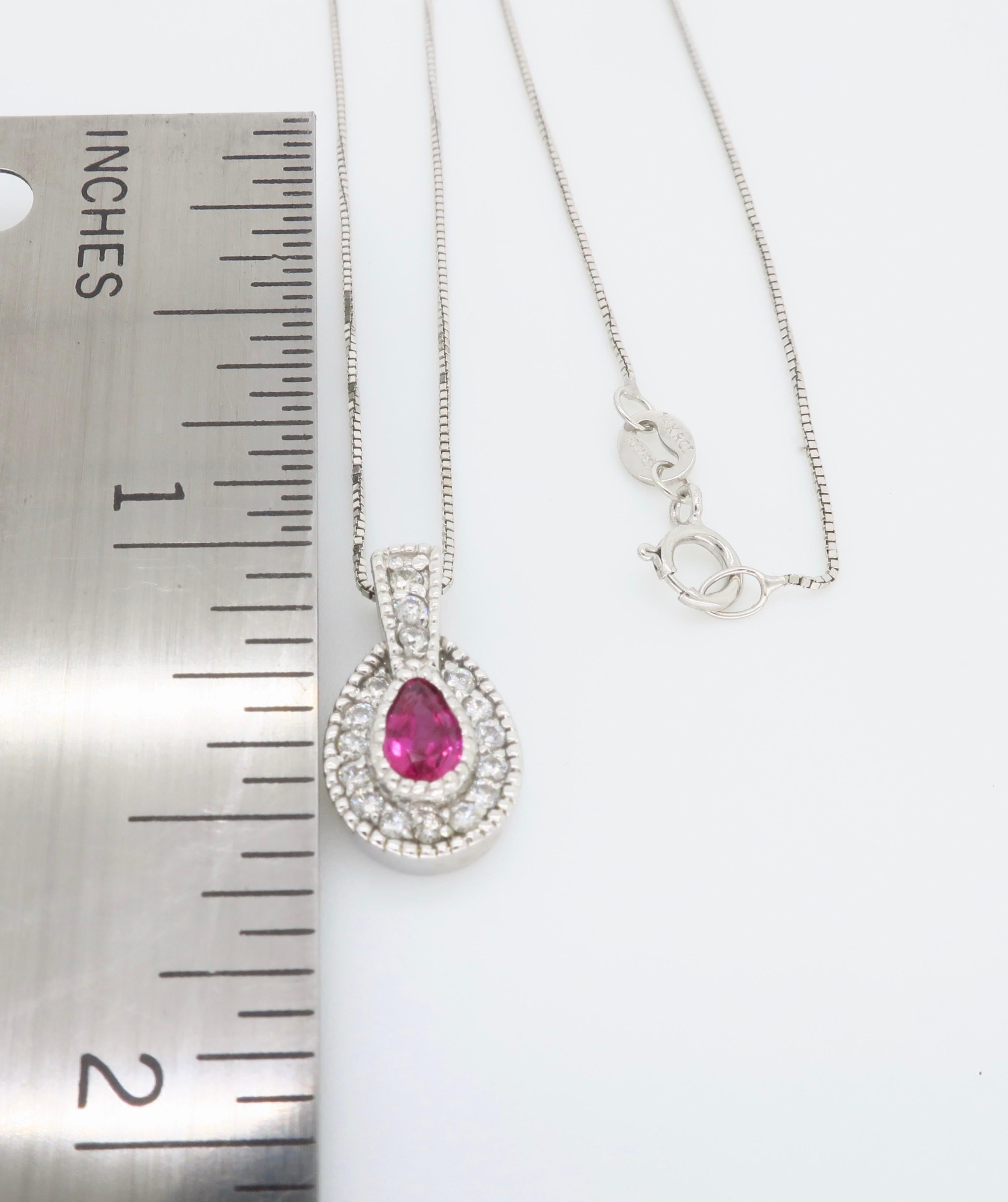 Ruby and Diamond halo style pendant necklace crafted in 14k white gold.

Gemstone: Ruby & Diamond
Gemstone Carat Weight: Approximately 4.9x3.25mm
Diamond Carat Weight: .19CTW
Diamond Cut: Round Brilliant Cut Diamonds
Color: Average G-I
Clarity:
