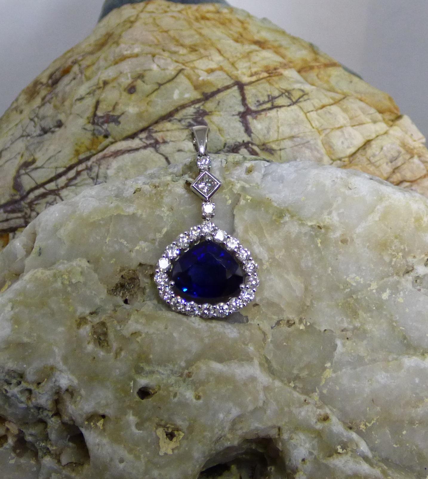 This handmade pendant is set with a an 11X10mm pear shaped Sapphire weighing 3.61cts.  It is surrounded by round Diamonds with two round and one Princess cut Diamond up set up to the bale. Total Diamond weight is 1.13ct.  The total length of the