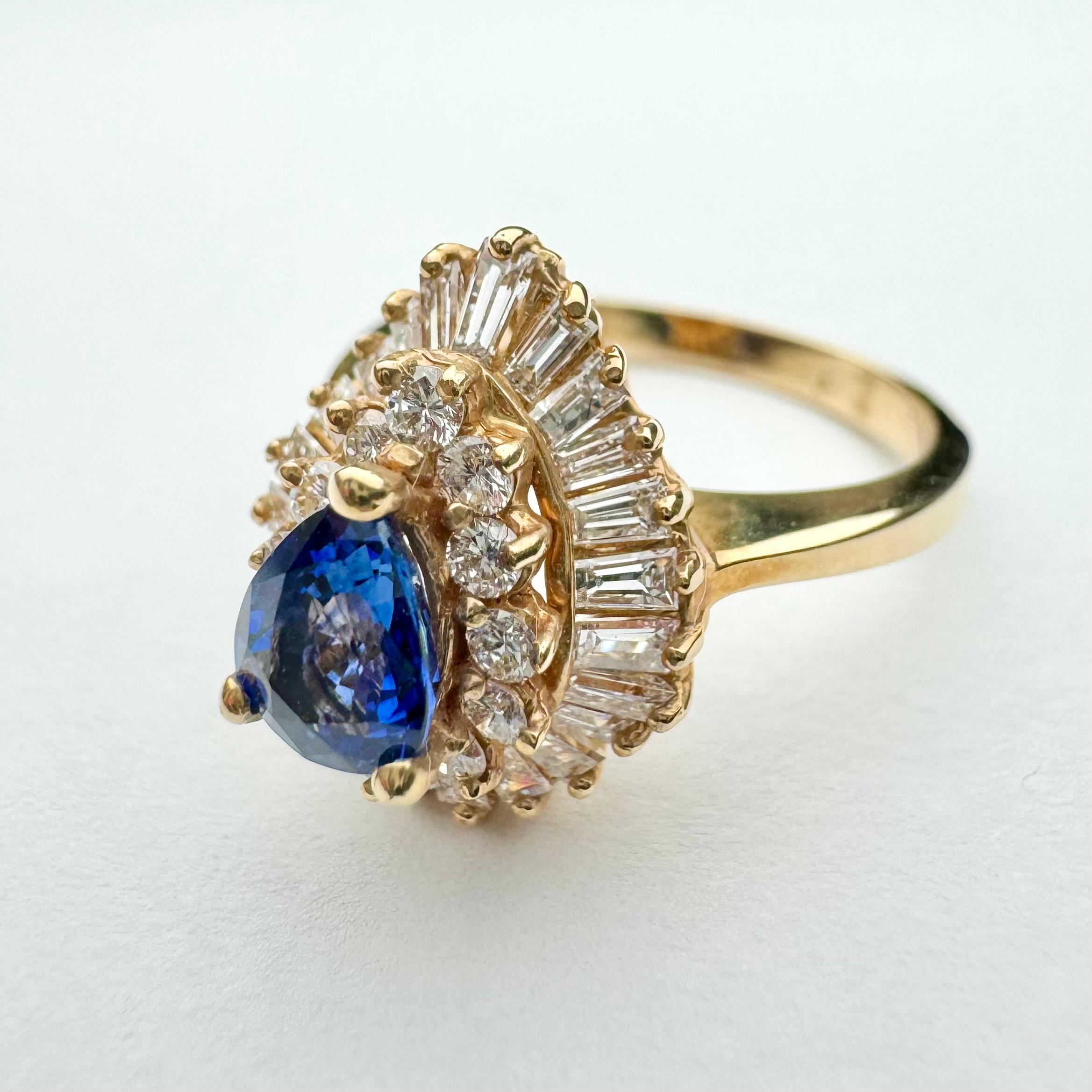 Gorgeous piercing blue, pear shaped sapphire and diamond ring in 14k yellow gold.
Unique and masterfully set in double halo. Inner halo consists of12 sparkling white round diamond and outer halo is in ballerina style with delicate curves created by