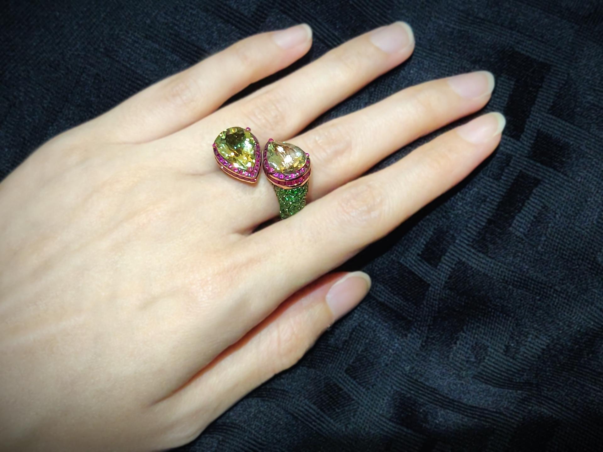 This splendid 18K rose gold bypass ring features impressive sizeable pear-shaped yellow beryls embellished with intense red rubies, round and baguette, at both ends. Its shanks are pavé-set with vivid green tsavorites.

Please let us know should you