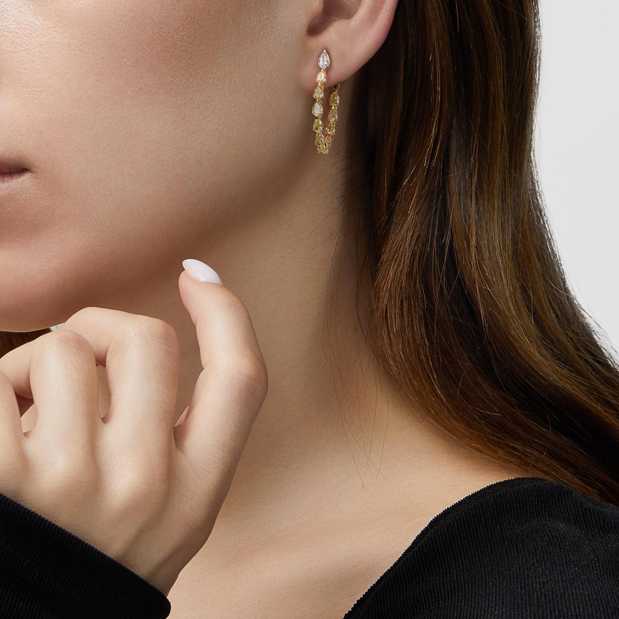 Vous serez radieuse avec nos boucles d'oreilles en diamant jaune en forme de poire. Un seul diamant blanc en forme de poire trône au niveau du lobe de l'oreille, puis laisse place à une cascade de diamants jaunes fantaisie en forme de poire. Ces