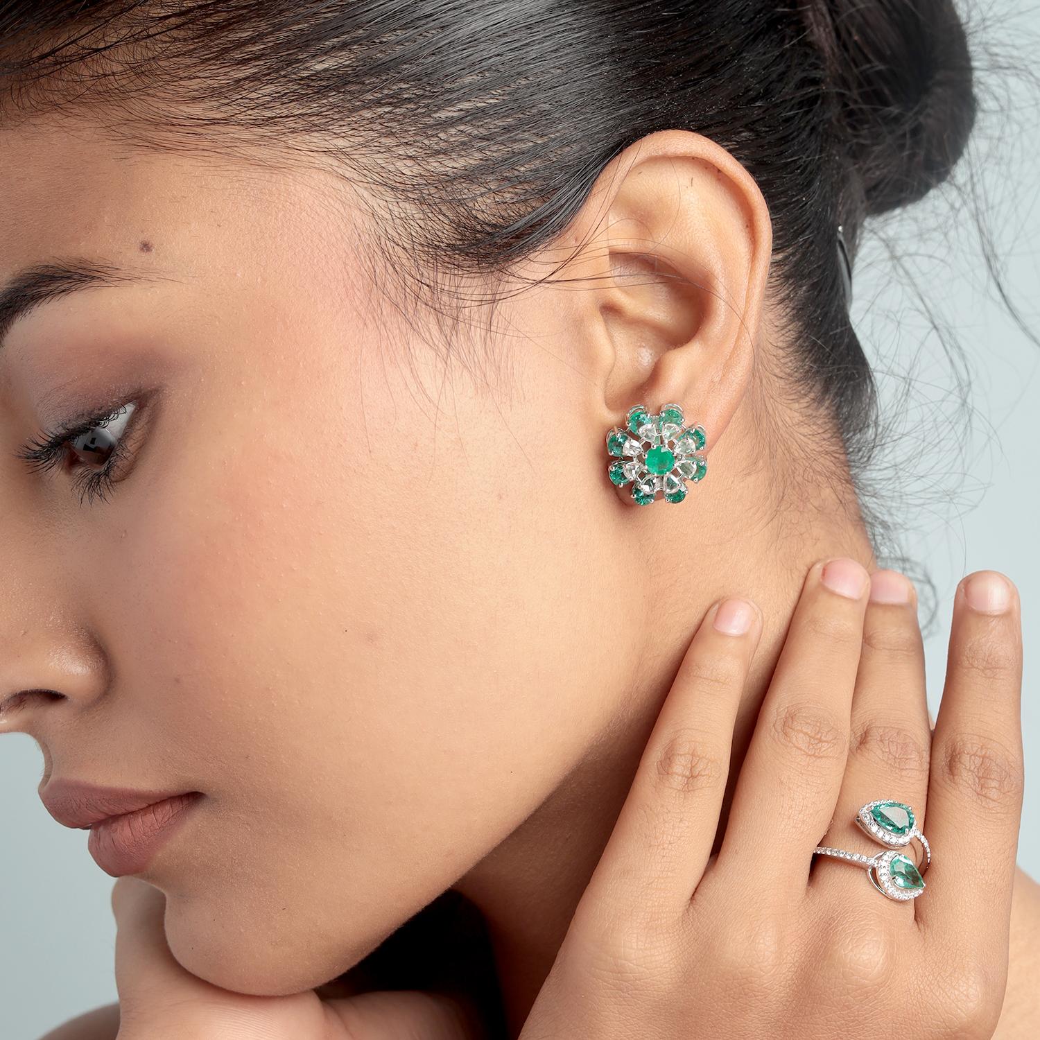 Remarquables et élégants, ces clous d'oreilles floraux sont ornés d'émeraudes de Zambie en forme de poire totalisant 6,98 carats, joliment rehaussées de 1,23 carat de diamants étincelants. Fabriqué en or blanc 18 carats, le design inspiré de la