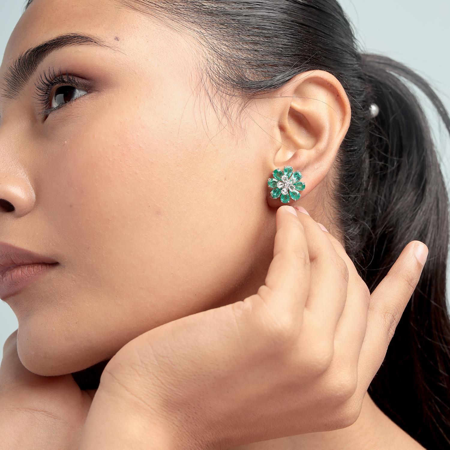 Gracieuses et vibrantes, ces boucles d'oreilles florales présentent de luxuriantes émeraudes zambiennes en forme de poire totalisant 5,40 carats, joliment entourées de 0,81 carat de diamants étincelants. Fabriqué de manière experte en or blanc 18