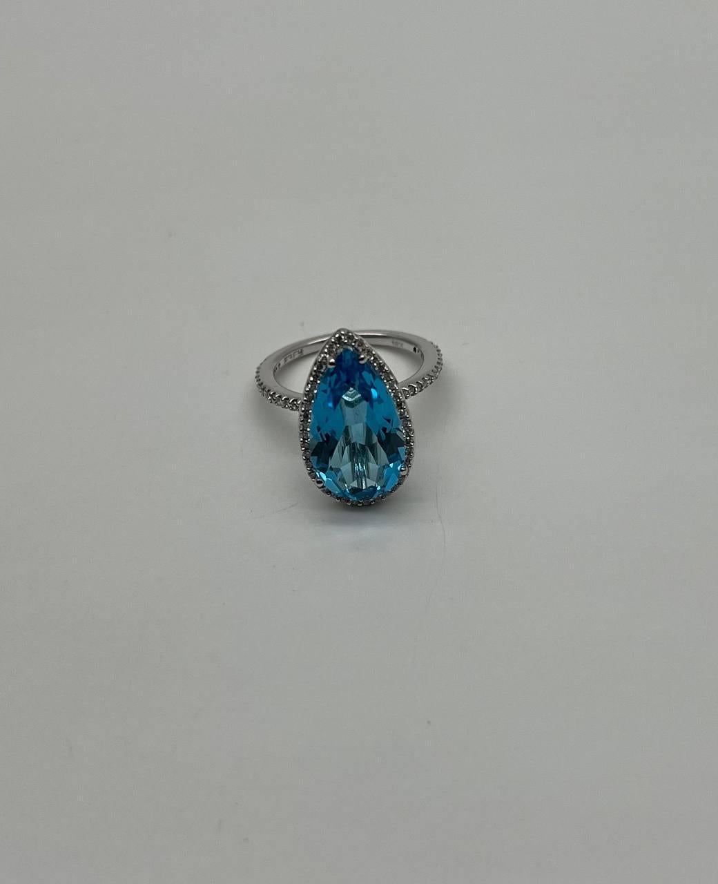 Elegant and Captivating.
Set with a Pear-Shaped Swiss Blue Topaz.
Accented by a Halo of Sparkling Diamonds.
Crafted in 14K White Gold.
0.20 CTW Diamonds 
4.71 Cts Swiss Blue Topaz