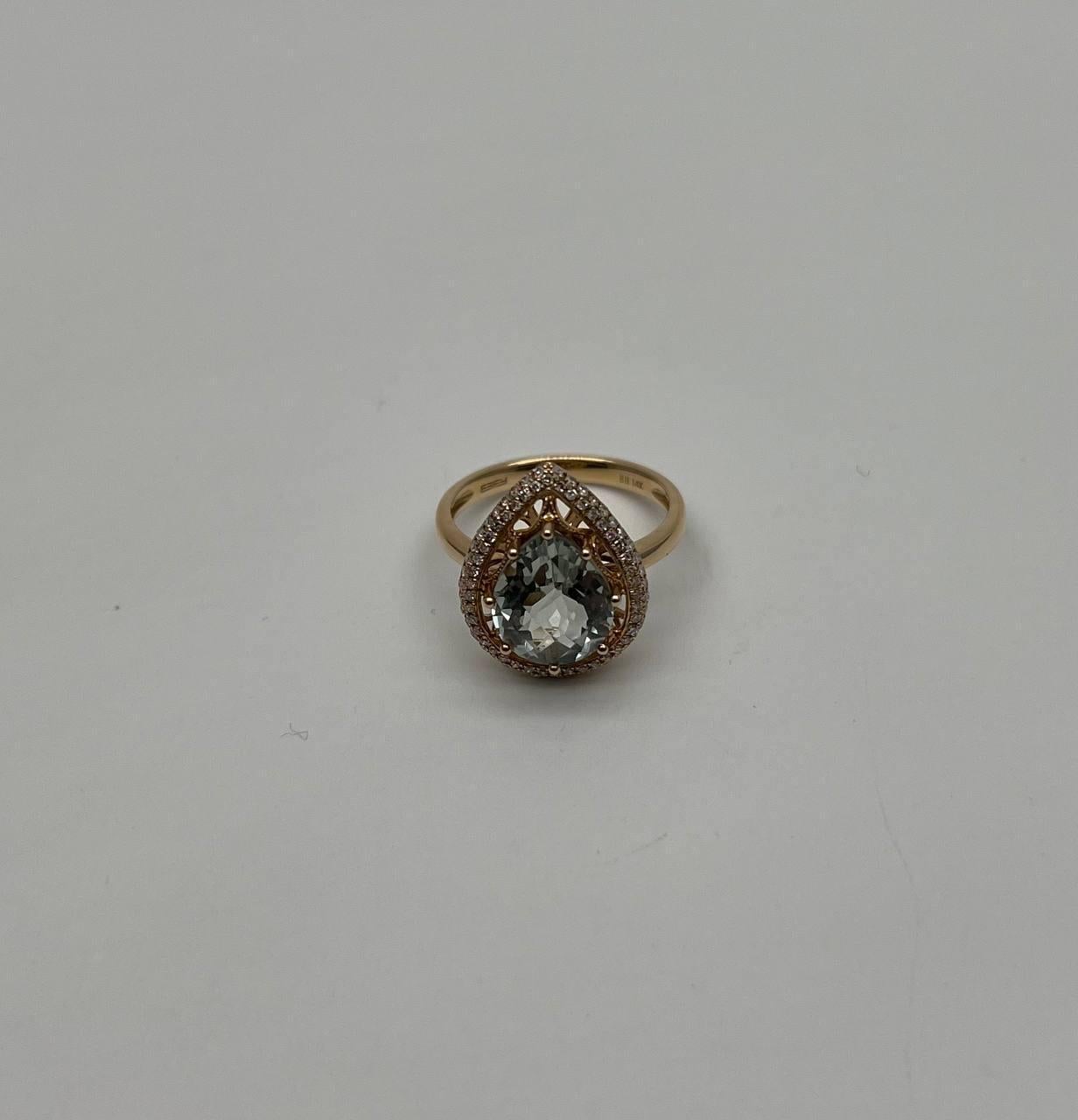 This exquisite ring is crafted with classic and modern details. The centerpiece features a stunning pear-shaped green Amethyst (prasiolite), surrounded by a halo of sparkling diamonds. The band is made of polished gold, enhancing the brilliance of