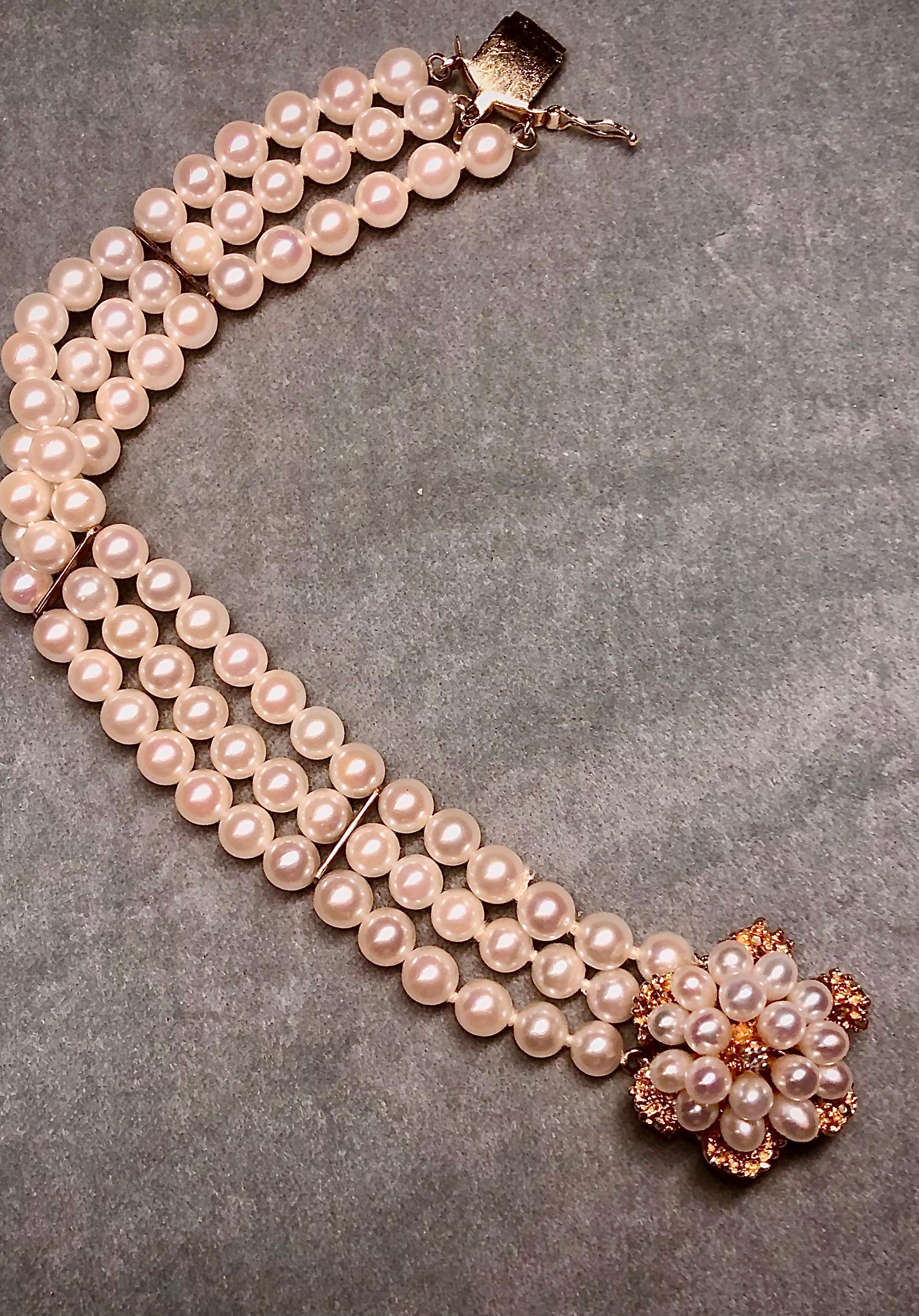 A very attractive three strand vintage bracelet with round high luster creamy white pearls. The bracelet is centered on an intricate 14kt gold floral motif clasp. The clasp is embellished with multiple pearls matching in color with the strands of