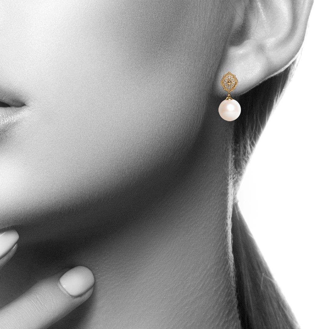 Part of the brand new 'Mauresque' collection by Natalie Barney, these earrings features a 10mm Round White Freshwater Pearl dangling from a Moorish inspired earring top. The classic Pearl Drop Earrings are reinvented whilst staying an elegant, all