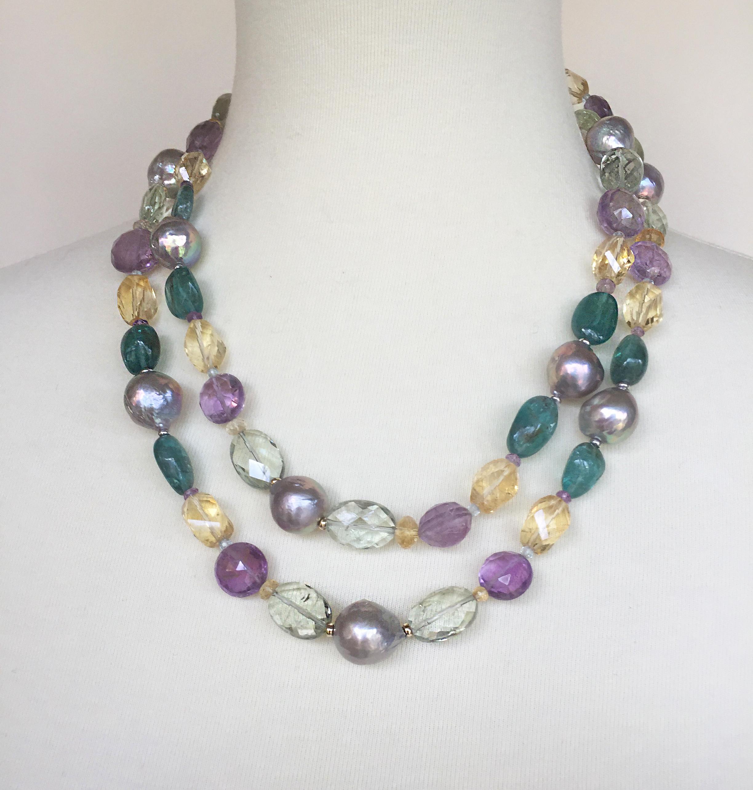 This pearl, amethyst, citrine, and blue topaz necklace with 14k white and yellow gold is beautifully colorful, with different semi-precious stone beads. The large baroque grey pearls, green and purple amethyst, citrine, and London blue topaz shine