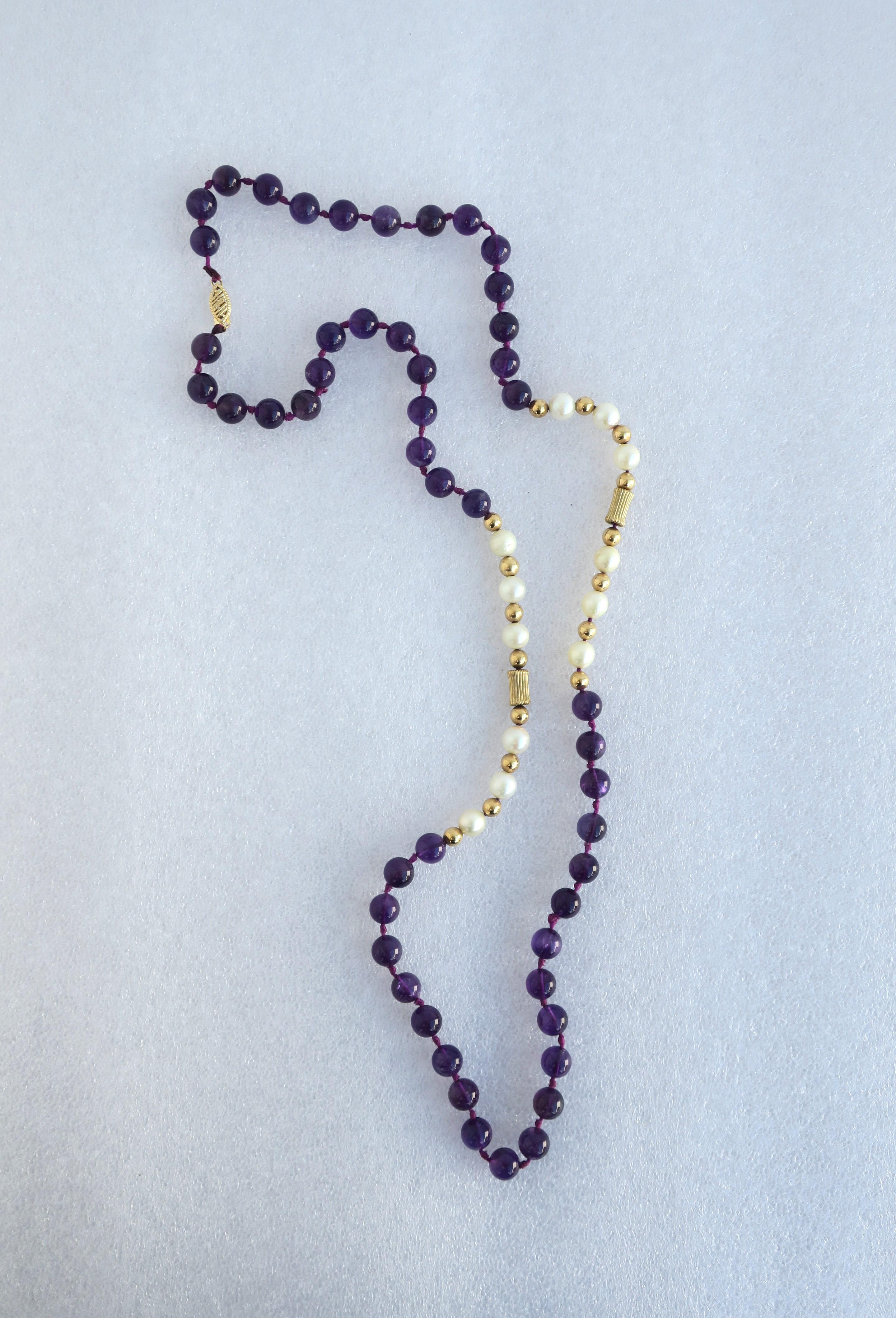 A beautiful bead necklace comprised of cultured pearls, purple amethyst beads, 14-karat gold beads (in two shapes), finished with a 14-karat gold clasp (shown in last two image.) Necklace measures 28