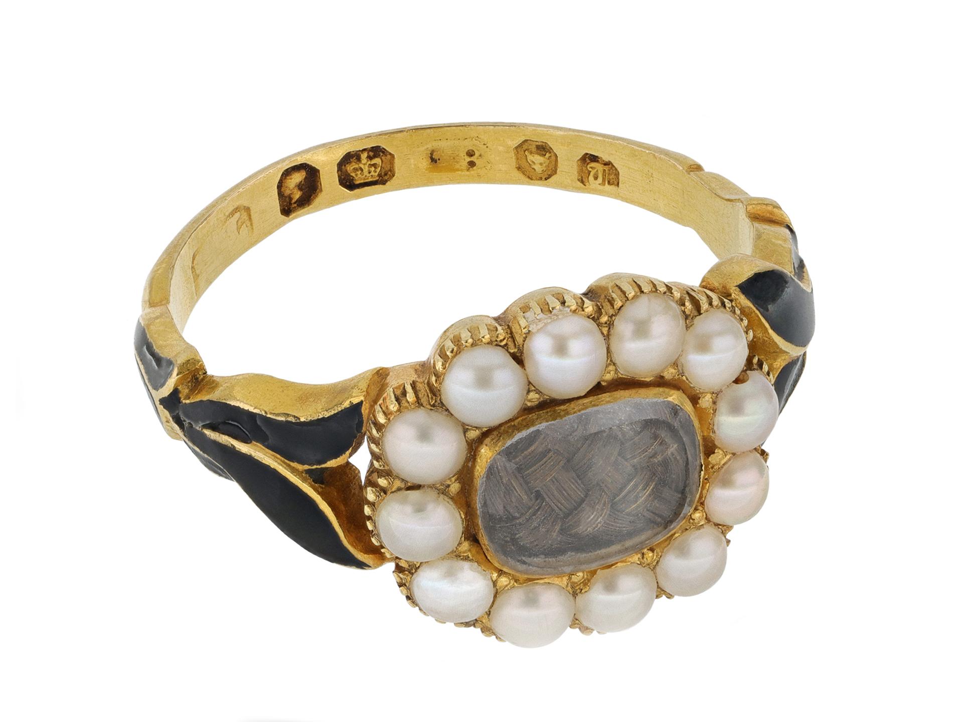 Pearl and black enamel memorial ring. Set to centre with an oblong crystal slice covering plaited hair in a closed back setting, encircled by a row of twelve natural half seed pearls in closed back grain and cut-down settings, to an  intricate