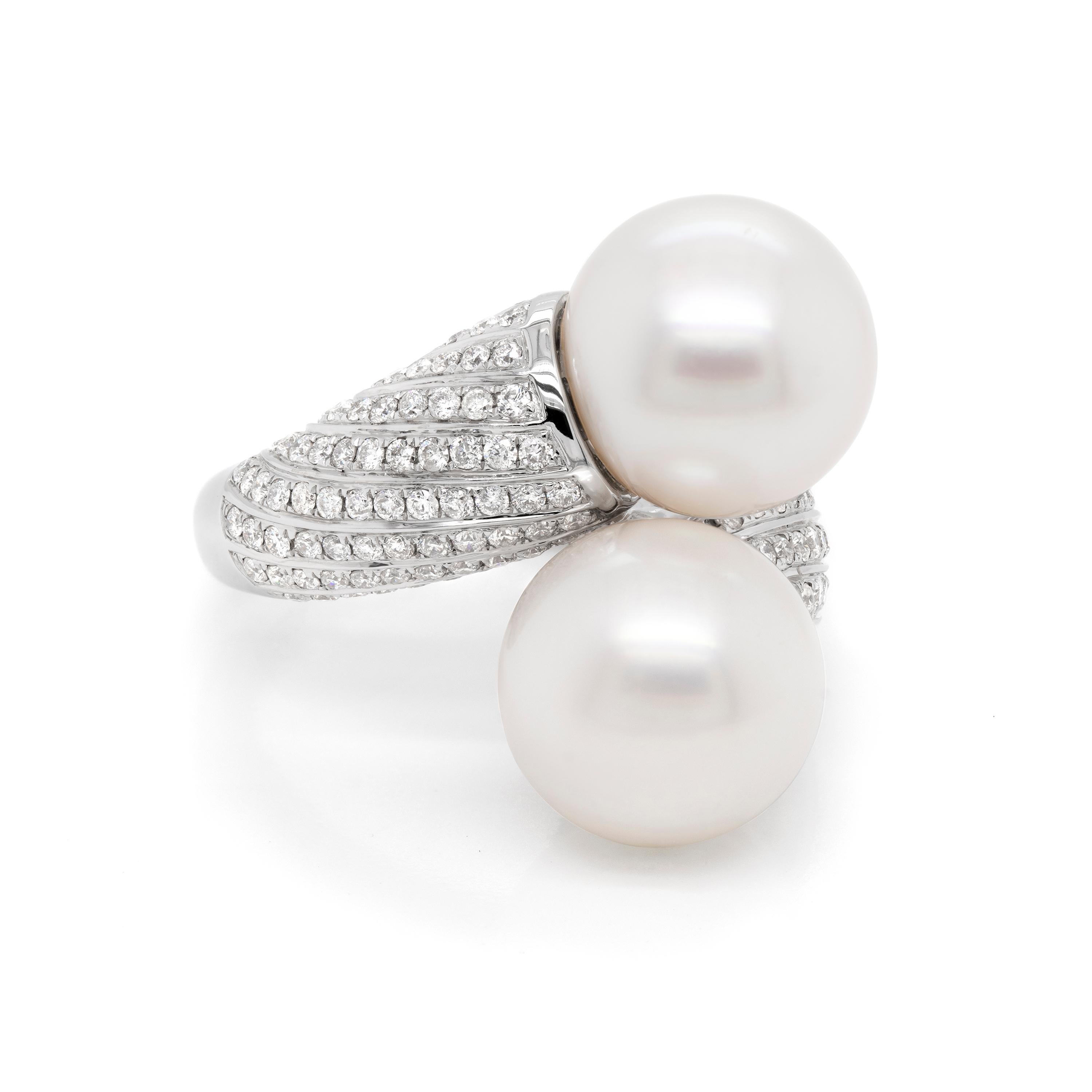 This impressive cocktail ring features two 13.2mm cultured pearls in the centre of a cross-over mount, pavè set with round brilliant cut diamonds with a total weight of 1.70 carats. The band graduates from 10.5mm to its finest point of 3.9mm. All