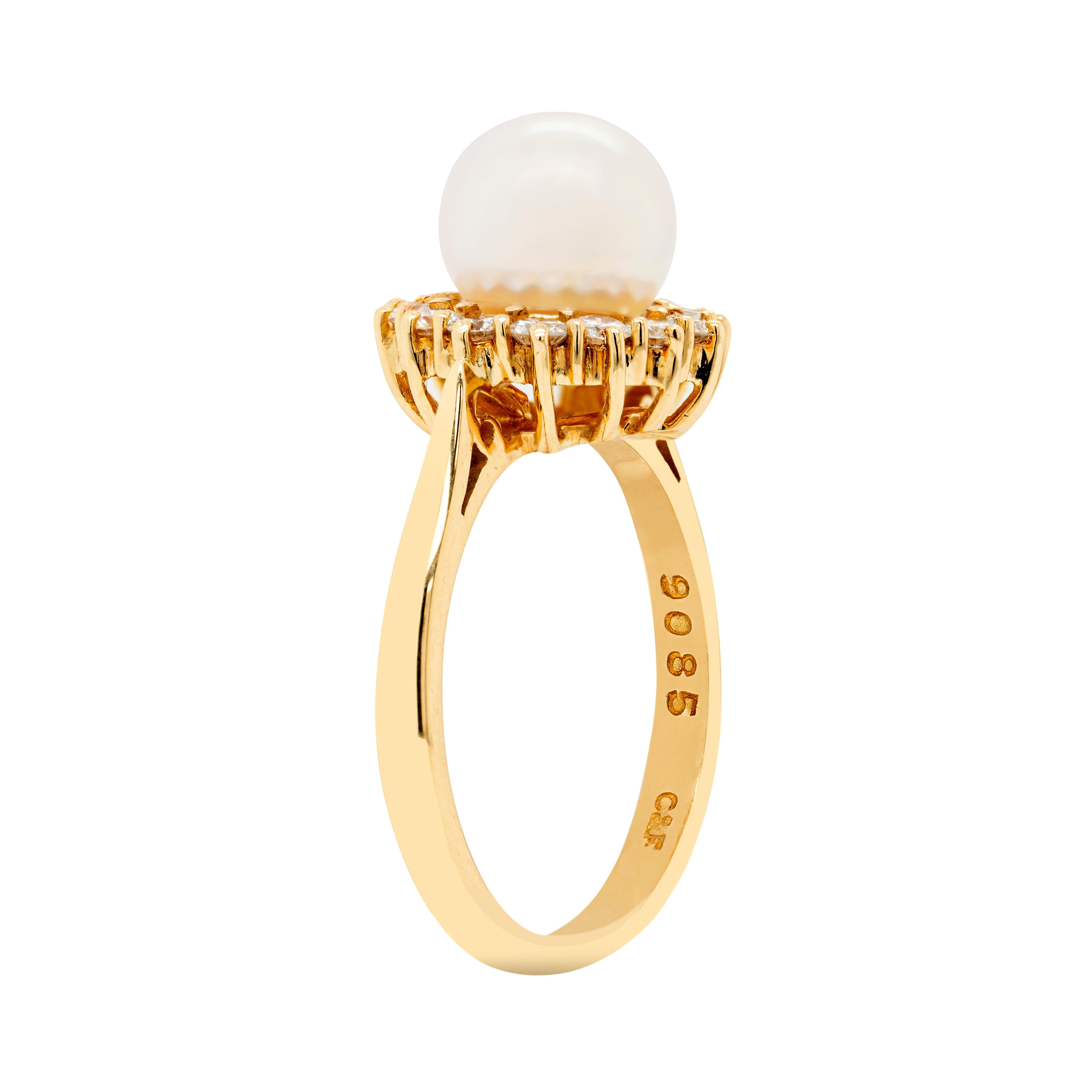Cette bague de fiançailles exquise et charmante présente une magnifique perle de culture blanche mesurant 7,8 mm, entourée de 14 diamants ronds de taille brillant sertis en griffe de qualité supérieure, pesant environ 0,70 ct. La délicate grappe est