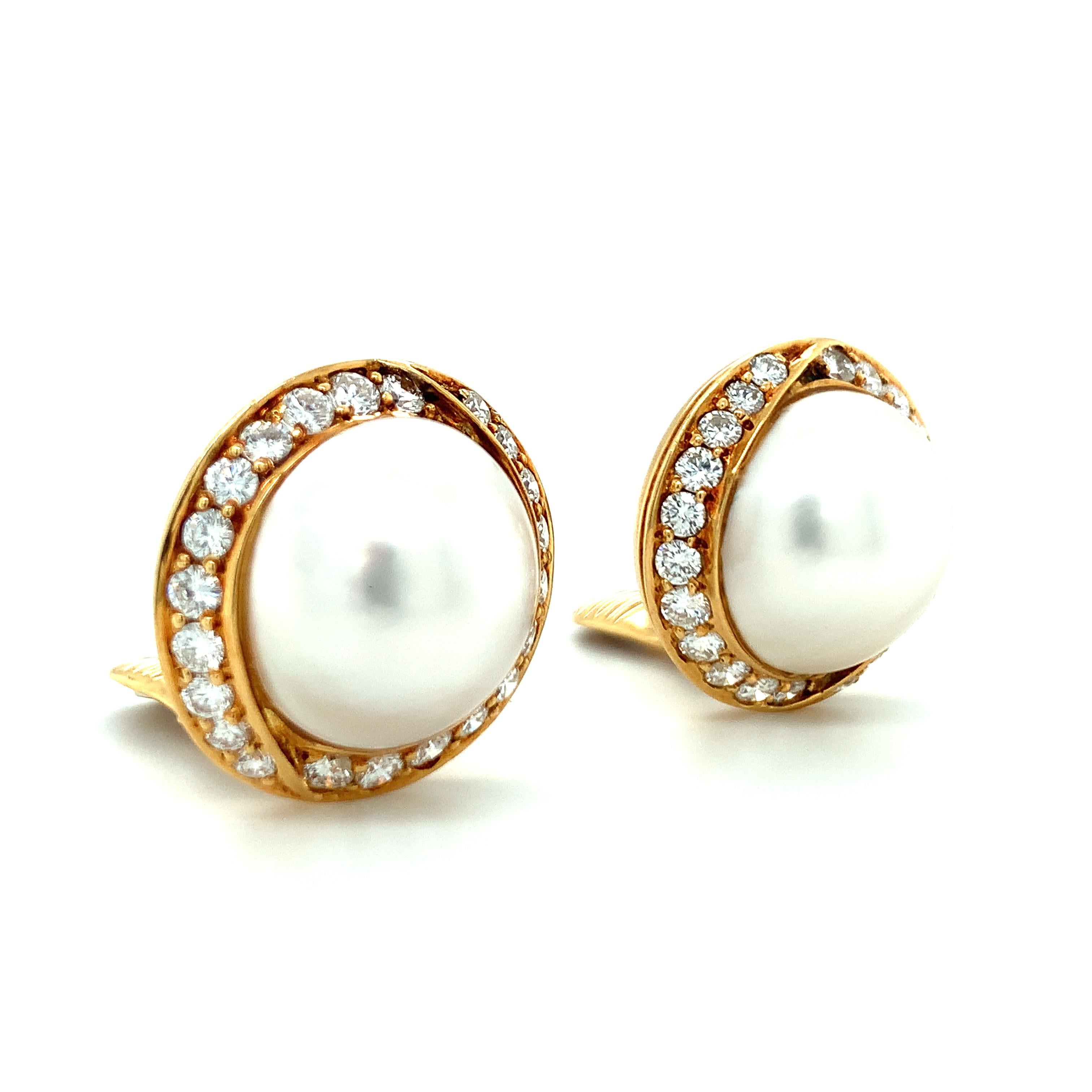 One pair of white mabe cultured pearl and diamond 18K yellow gold earclips featuring two pearls measuring 17 millimeters in diameter with a diamond border totaling 44 round brilliant cut diamonds weighing 2.50 ct. with G color and VS-1