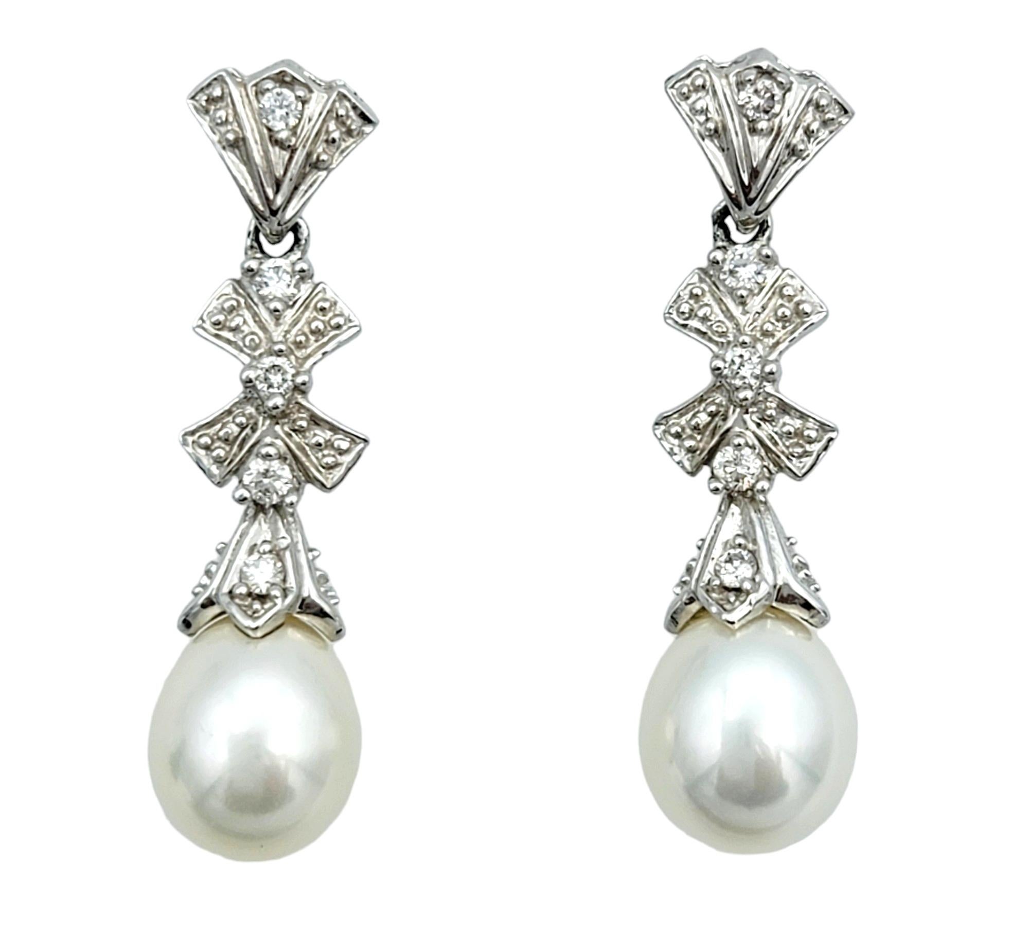This exquisite pair of pearl and diamond dangle earrings are meticulously crafted in 14 karat white gold. These elegant earrings each feature a single lustrous pearl at the bottom, providing a timeless focal point that exudes
