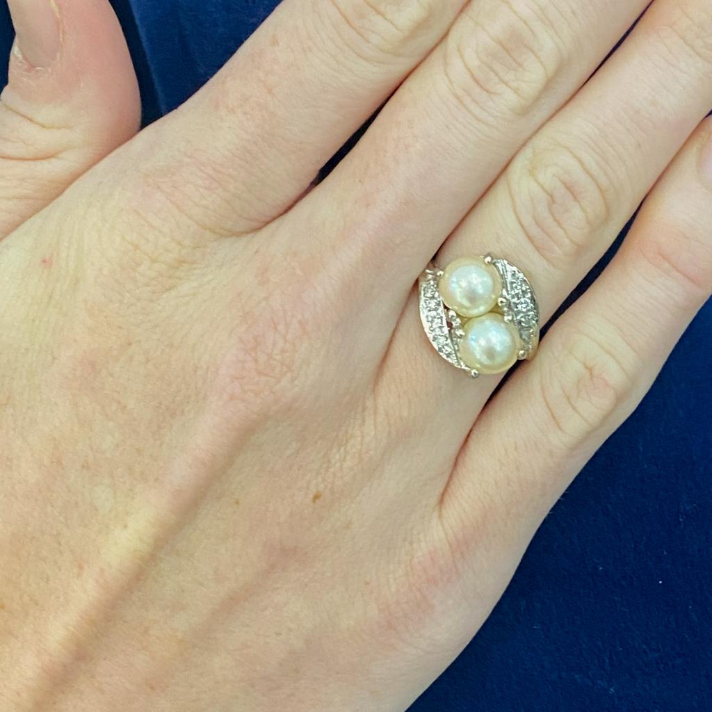 These matched pearls sit on a diagonal in a beautiful vintage bypass design ring. Two sweeping lines of diamonds curve along the pearls, set in white gold. Celebrate or honor a June loved one with this beautiful vintage bypass ring! Toi et moi rings