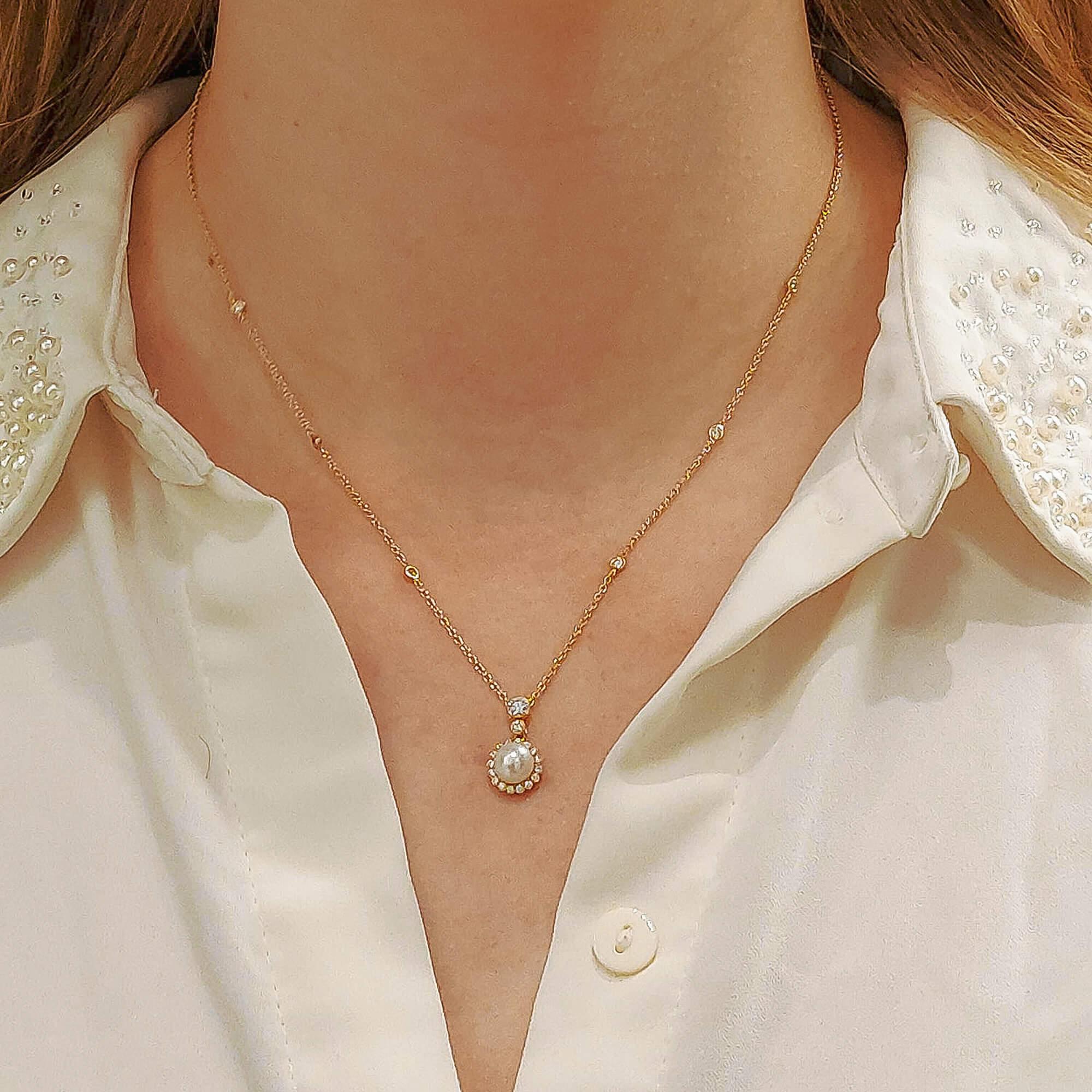 A stunning pearl and diamond pendant set in 18k yellow gold. The pearl is of superior lustre and centrally set in a halo of 16 diamonds. The diamonds are in a scalloped surround and suspended from a further 2 articulated rub over set round brilliant