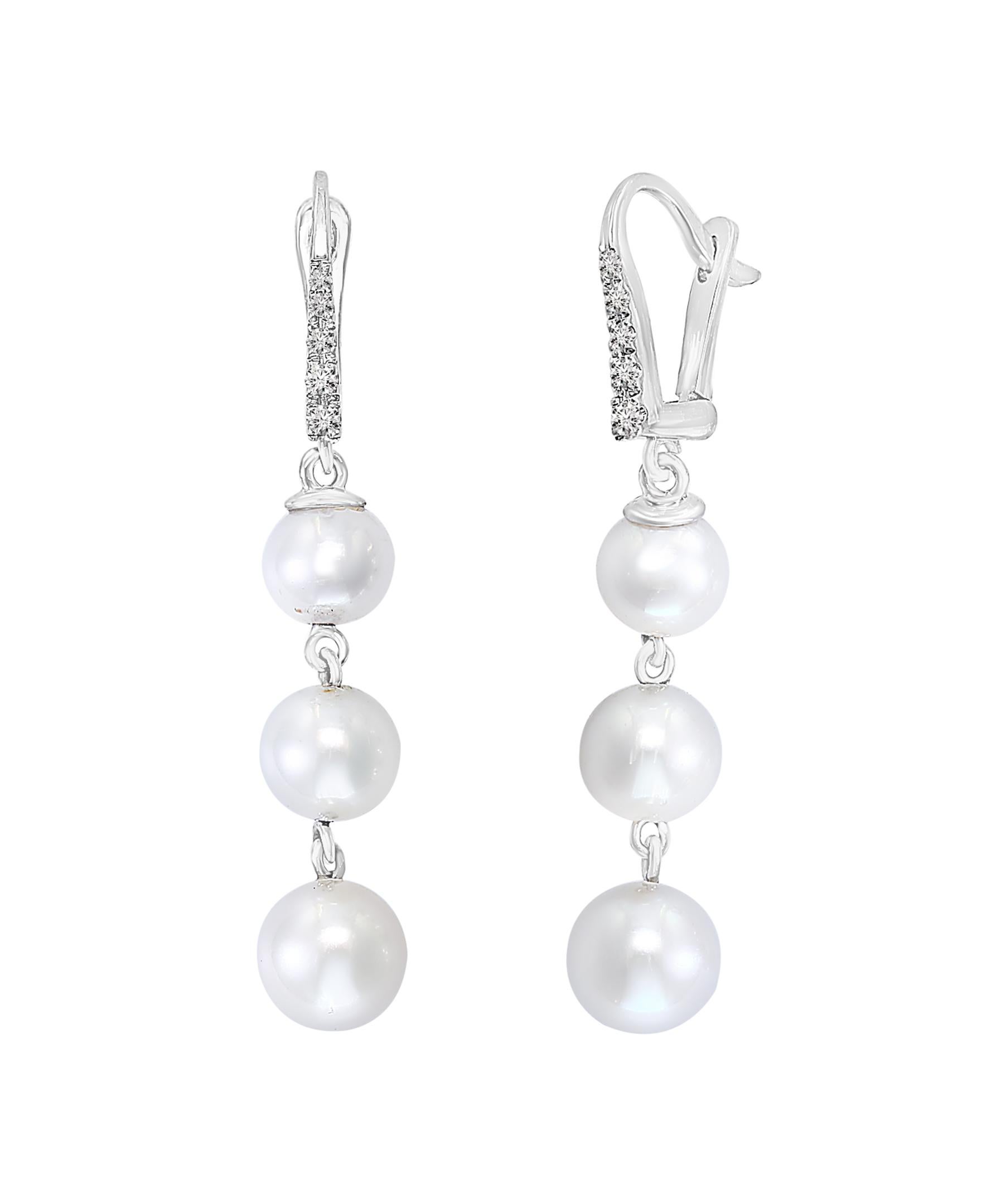 The cultured freshwater pearl earrings feature graduating 6-6.5mm, 6.5-7mm, and 7-7.5mm pearls. 
The pearls dangle off of a 14K white gold leverback with 0.085 total carats of diamonds. 
Great for everyday wear or for a dressy occasion, these