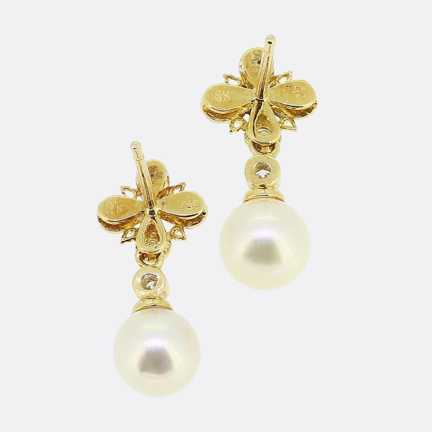 Here we have a pair of vintage 18ct yellow gold pearl and diamond drop earrings. Each piece showcases a diamond set quatrefoil motif with a matching round brilliant diamond and white cultured pearl falling freely below.

Condition: Used (Very