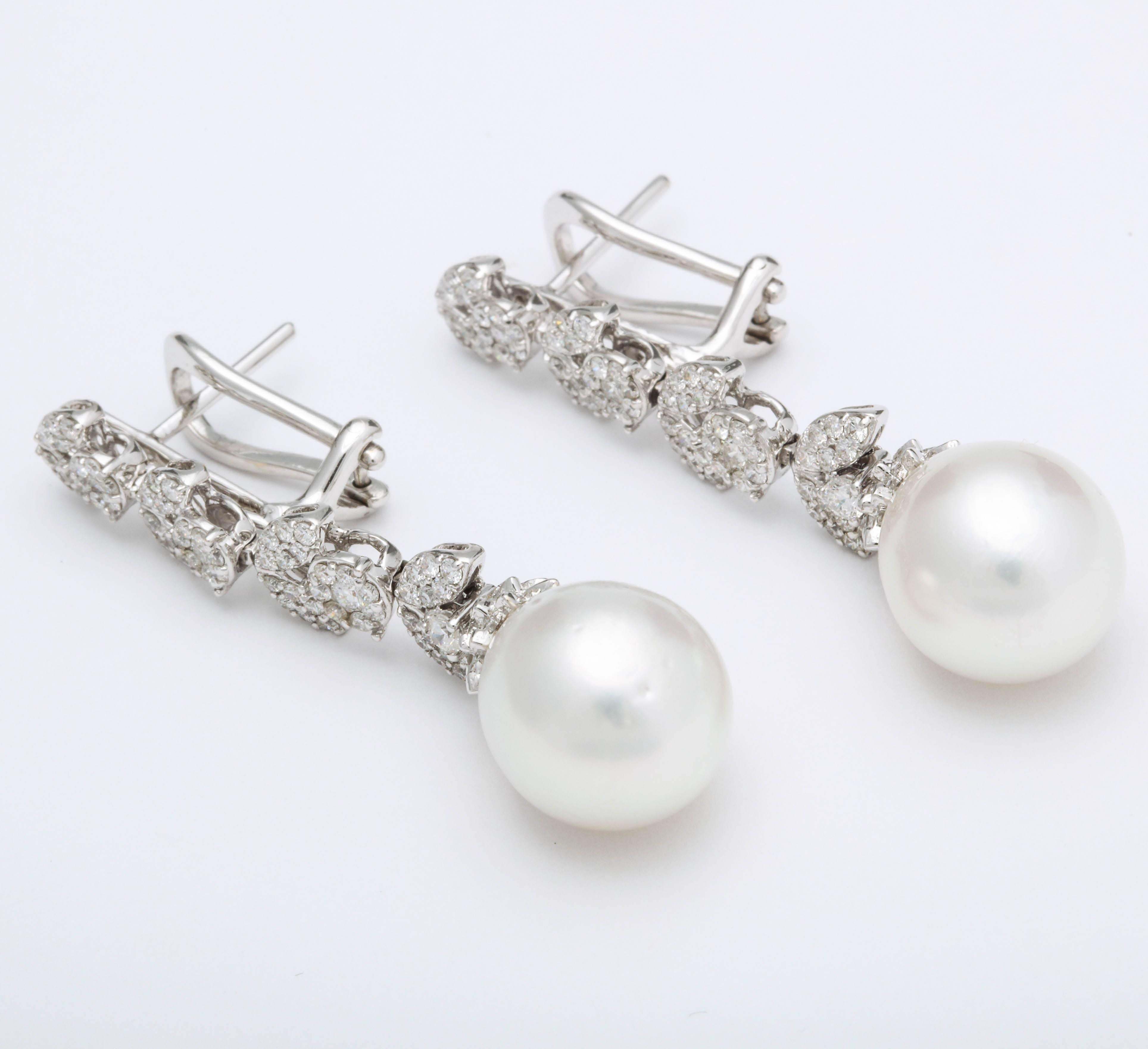 
An elegant pair of pearl and diamond dangle earrings. 

1.50 carats of white round brilliant cut diamonds set into round and marquise shapes with a pearl drop.

18k white gold 

Approximately 1.6 inches long

A timeless pair of earrings!