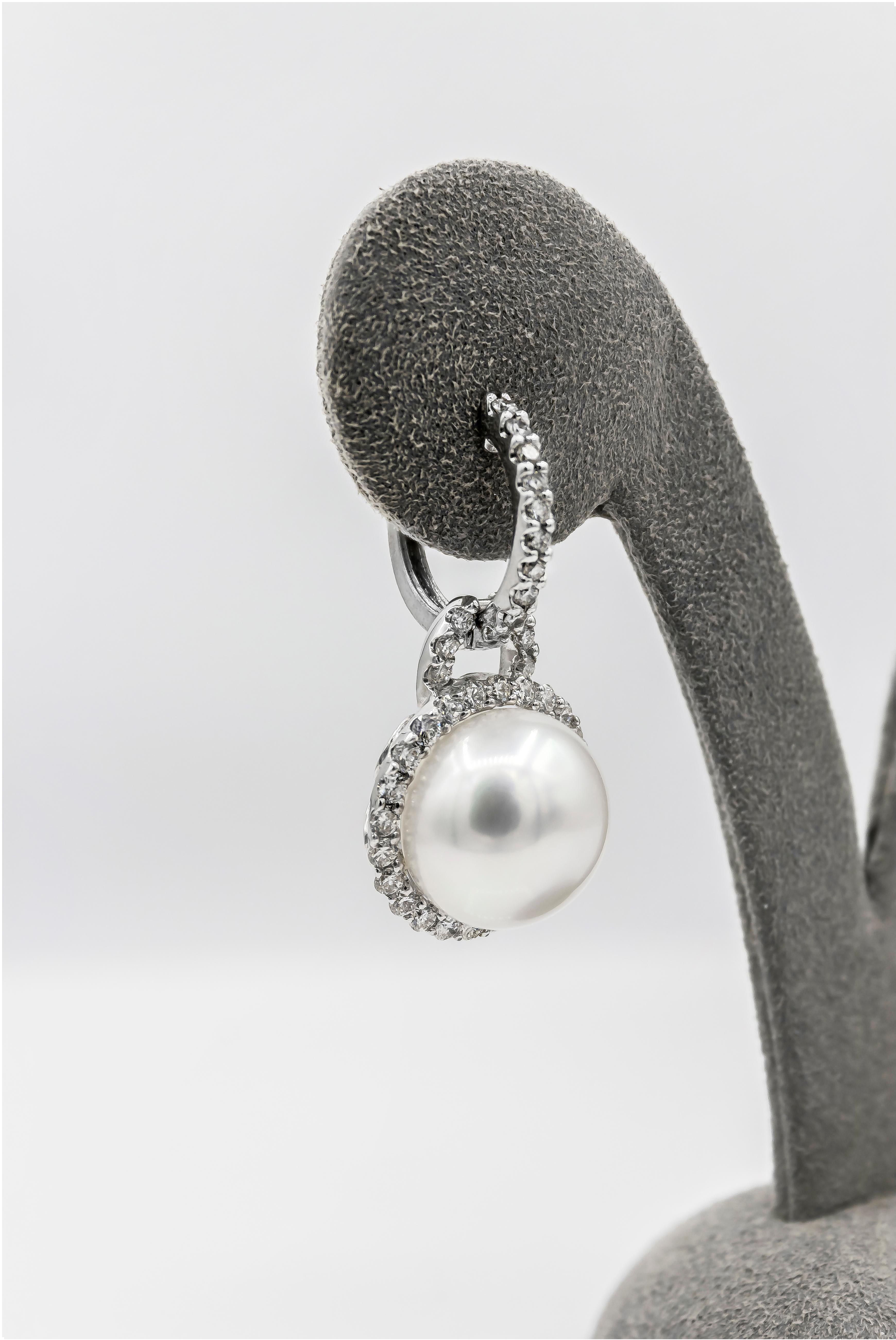 Each earring showcases a 12.40 millimeter pearl, surrounded by a single row of round brilliant diamonds. Suspended on a diamond-encrusted hoop made in 18 karat white gold. Total weight of the diamonds is 1.57 carats. 

Style available in different