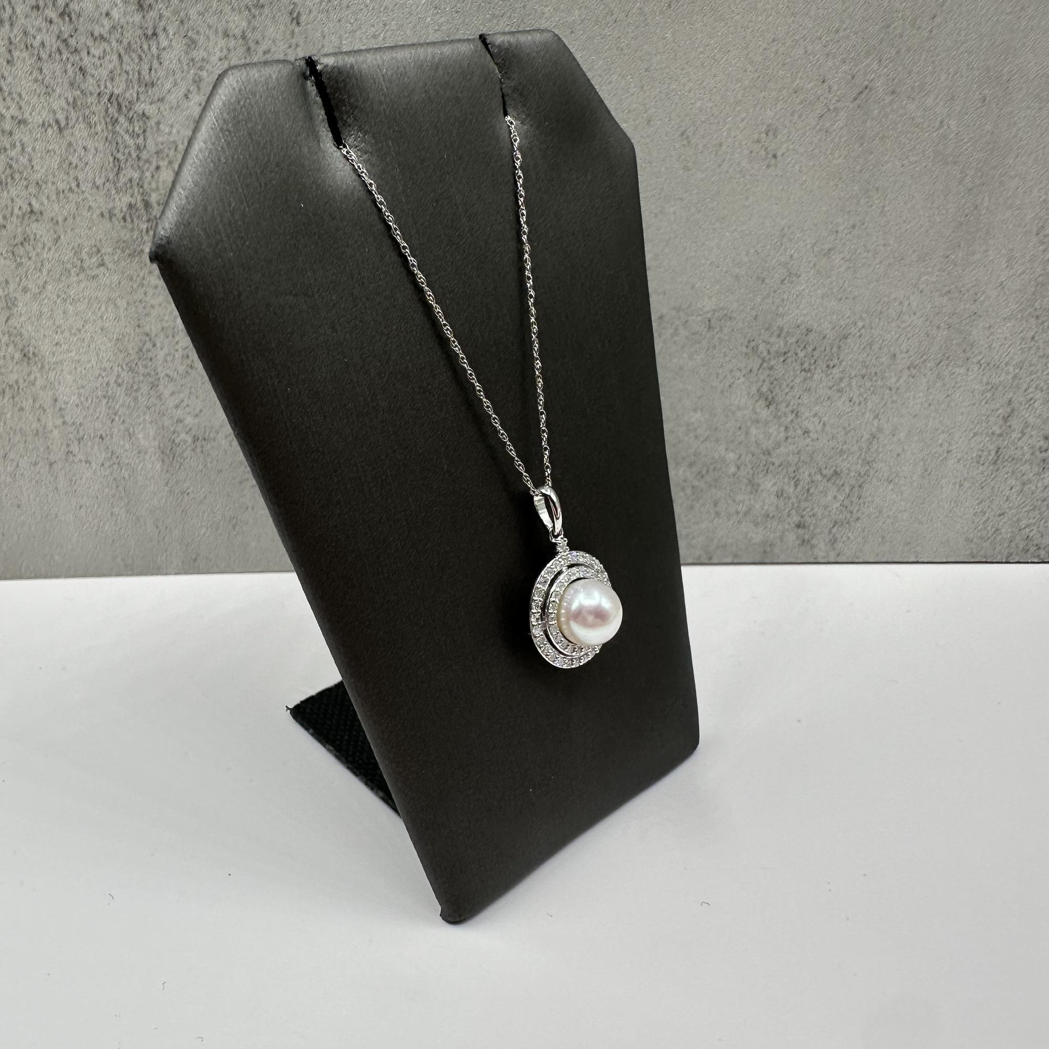 Cet élégant collier de perles et de diamants en or blanc 14kt présente une perle ronde d'environ 7,3 mm accentuée par 0,25 carats de poids total de diamants ronds de taille unique GH I1 naturels. La perle lumineuse est magnifiquement complétée par