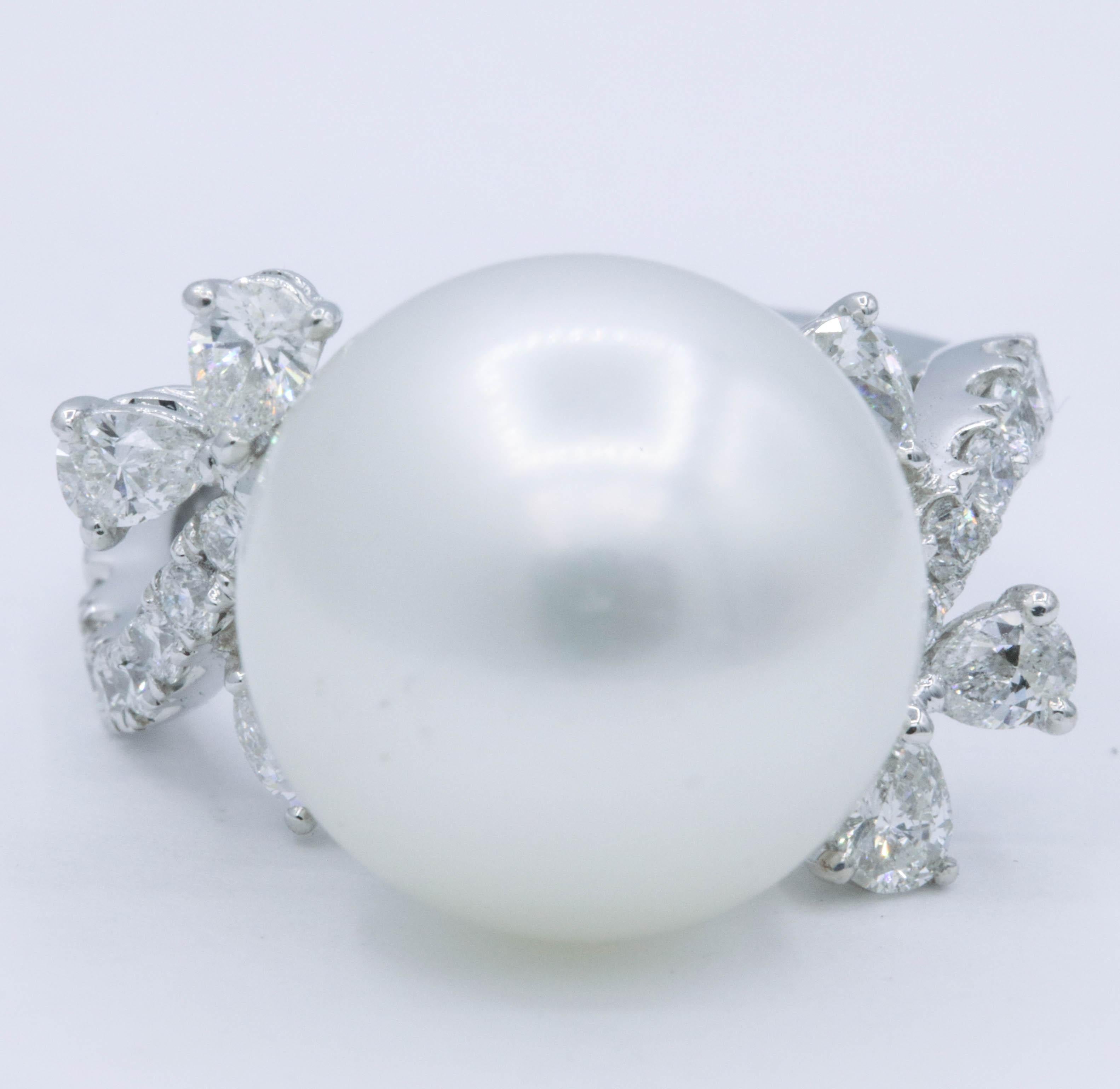 18K White gold ring featuring one center pearl, 14.2mm, flanked with 6 pear shape diamonds, 0.59 carats, and 14 round diamonds weighing 0.40 carats. 
Color: G-H
Clarity: SI
