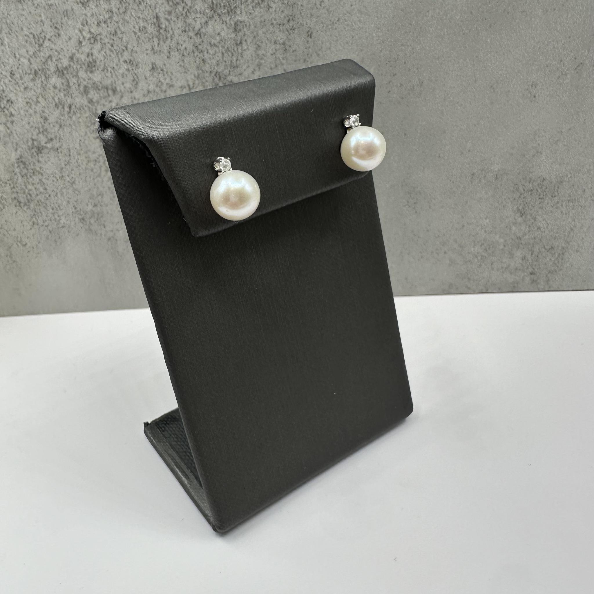 Ces magnifiques boucles d'oreilles perles et diamants en or blanc 14kt présentent des perles rondes d'environ 9-9,1 mm accentuées par 0,10 carats de poids total de diamants ronds GH naturels, I+I. Les perles blanches classiques rayonnent d'élégance