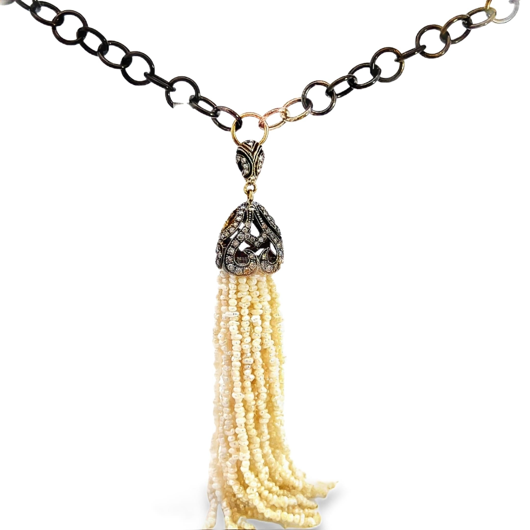 Ce superbe collier à pompon en diamants et perles présente un design complexe, alliant le charme antique à l'élégance moderne. Le collier est composé d'un pompon de 25 perles suspendues à un baril clouté de diamants de couleur champagne antique.
La