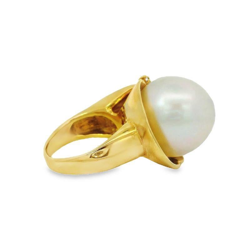 Dieser Cocktailring aus 18 Karat Gold zeigt in der Mitte eine wunderschöne 16 mm große Perle, die mit Diamanten besetzt ist. Es ist ein klassisches und elegantes Statement. Wiegt 19,29 Gramm. Größe 6.