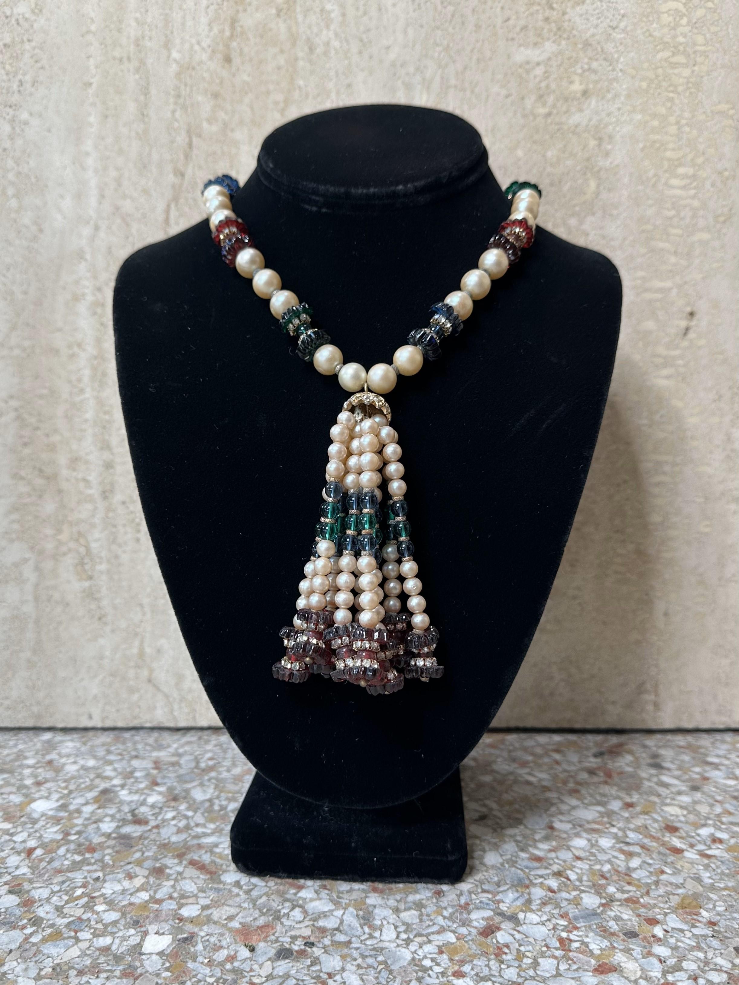 La collana di perle (finte) e perline con nappe è un pezzo straordinario e sfaccettato che combina un'eleganza senza tempo con una struttura dinamica e un movimento. Le perle conferiscono raffinatezza, mentre le perline e le nappe aggiungono