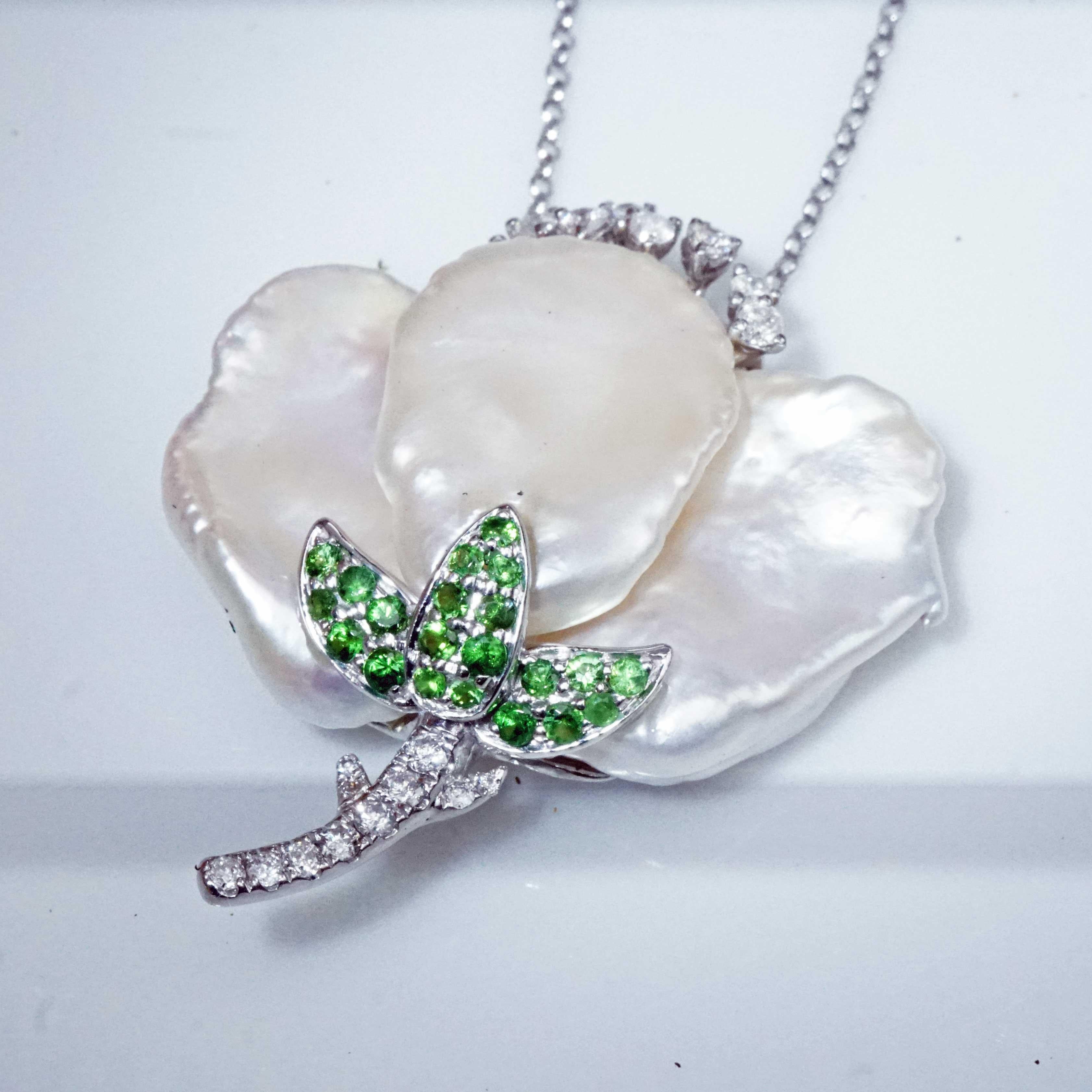 this flower will never wither frozen forever precious flower design made of three-part white freshwater pearl in fine quality, frame and flower stem set in 750 white gold and decorated with fine green tsavorites totaling approx. 0.30 ct and full-cut