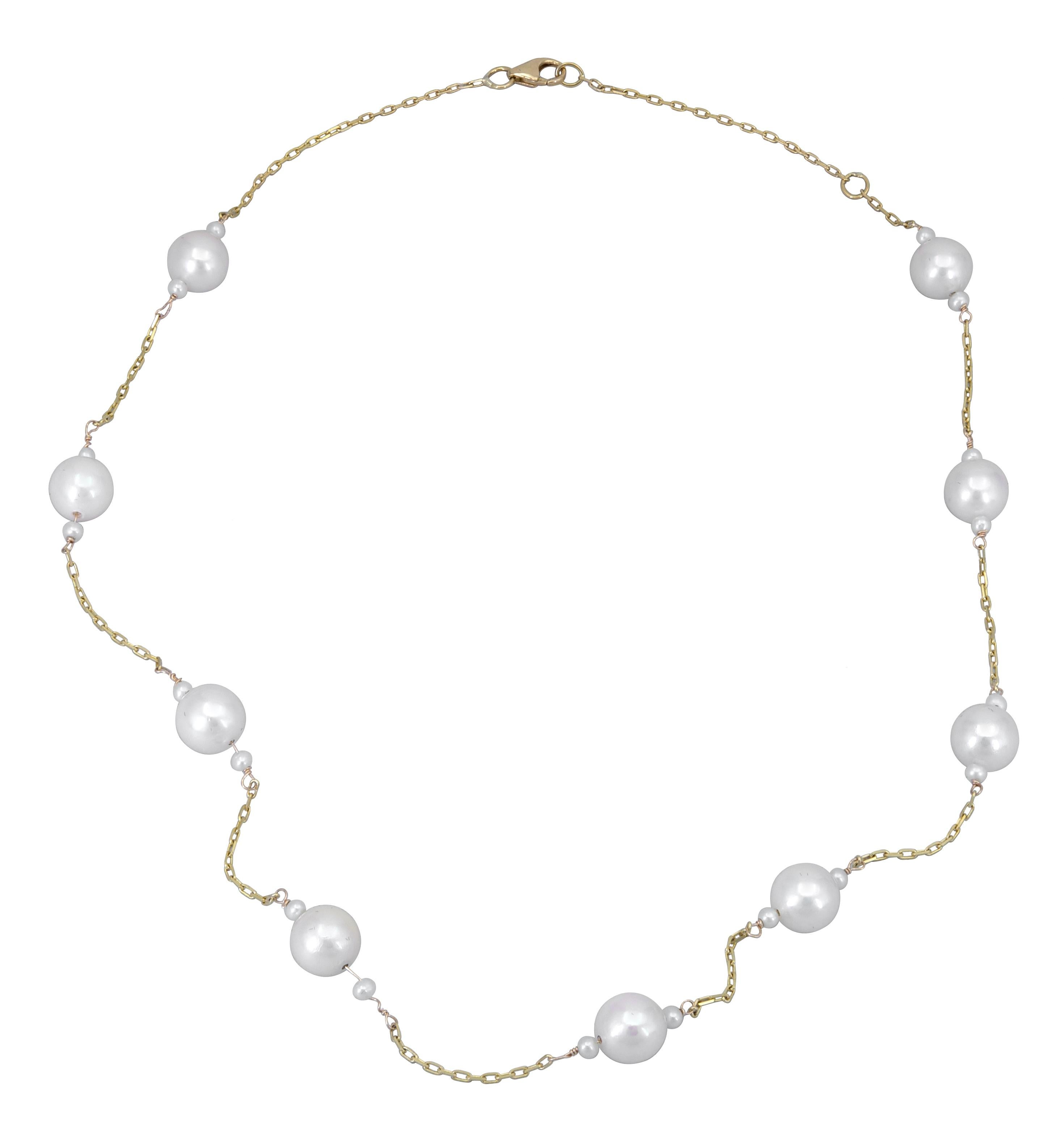 A stylish and simple necklace showcasing nine 7mm pearls, in-between seed pearls, spaced evenly in a modern 18k yellow gold chain. 
1.25 inch spacing between each pearl.
15 inch length.