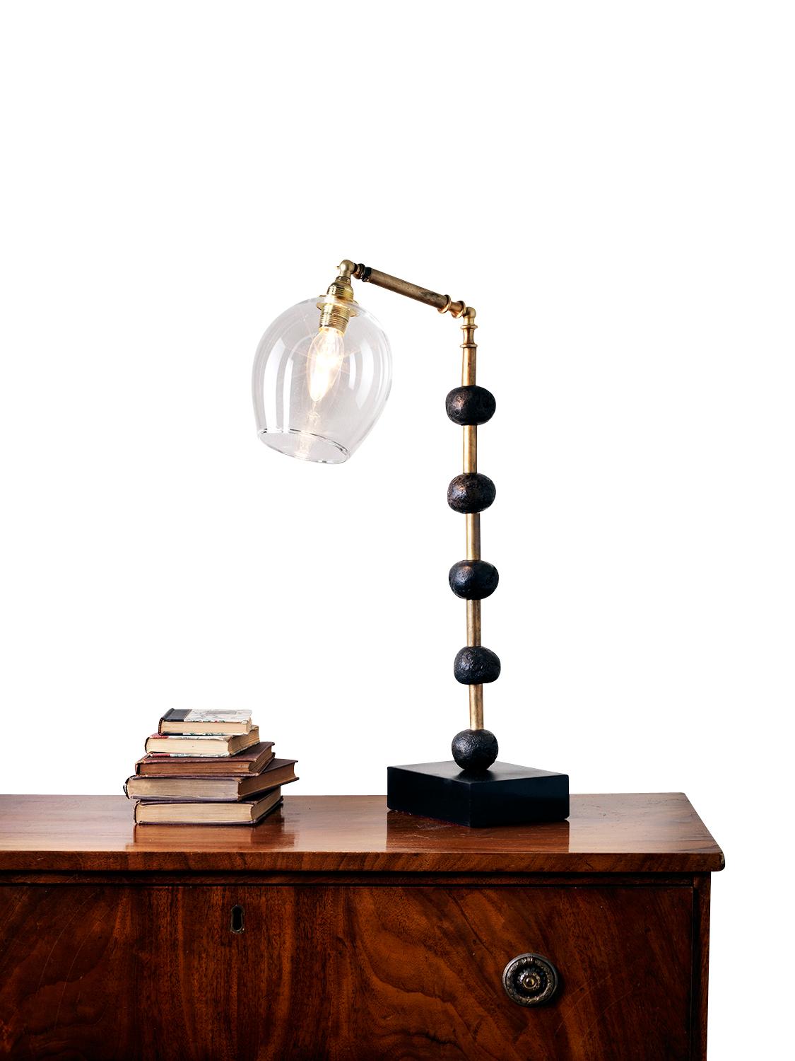 This contemporary Margit Wittig table lamp is mounted on a slate base and features multiple bronze resin handcrafted spheres. Each element is hand patinated to increase tonal contrast and enhance the surface texture.

This statement piece which will