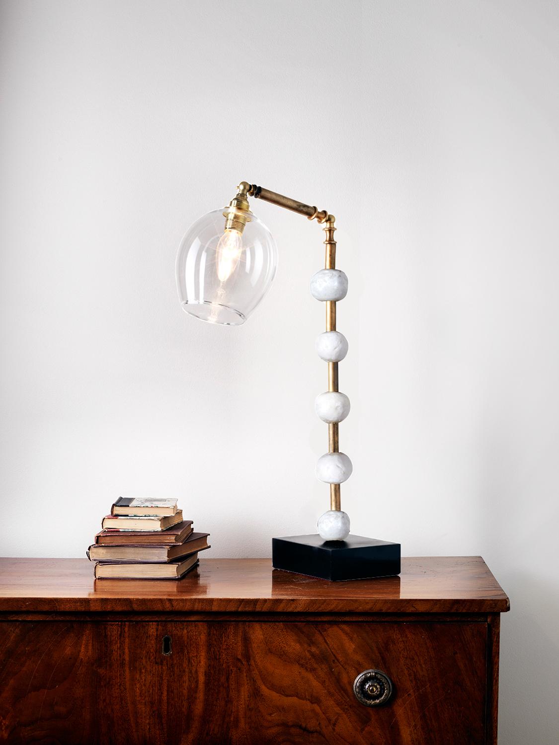 This contemporary Margit Wittig table lamp is mounted on a slate base and features multiple white resin handcrafted spheres. Each element is hand patinated to increase tonal contrast and enhance the surface texture.

This statement piece which
