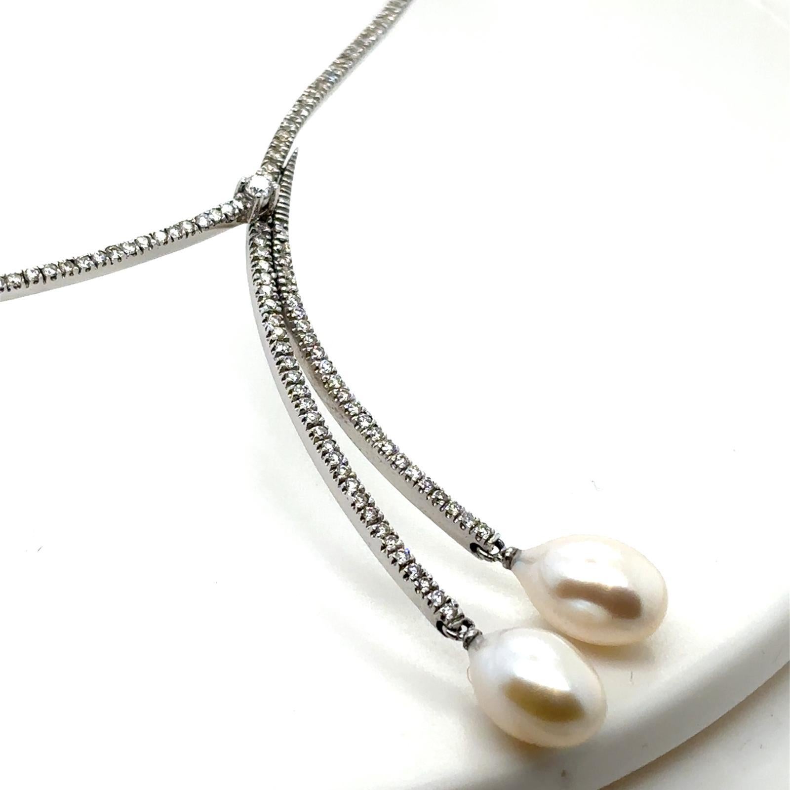 A modern pearl and diamond 14 karat white gold négligée style necklace

This striking necklace is composed of a rigid 14 karat white gold cross over front section claw set with round brilliant cut diamonds for a total of 1.27cts, assessed as G