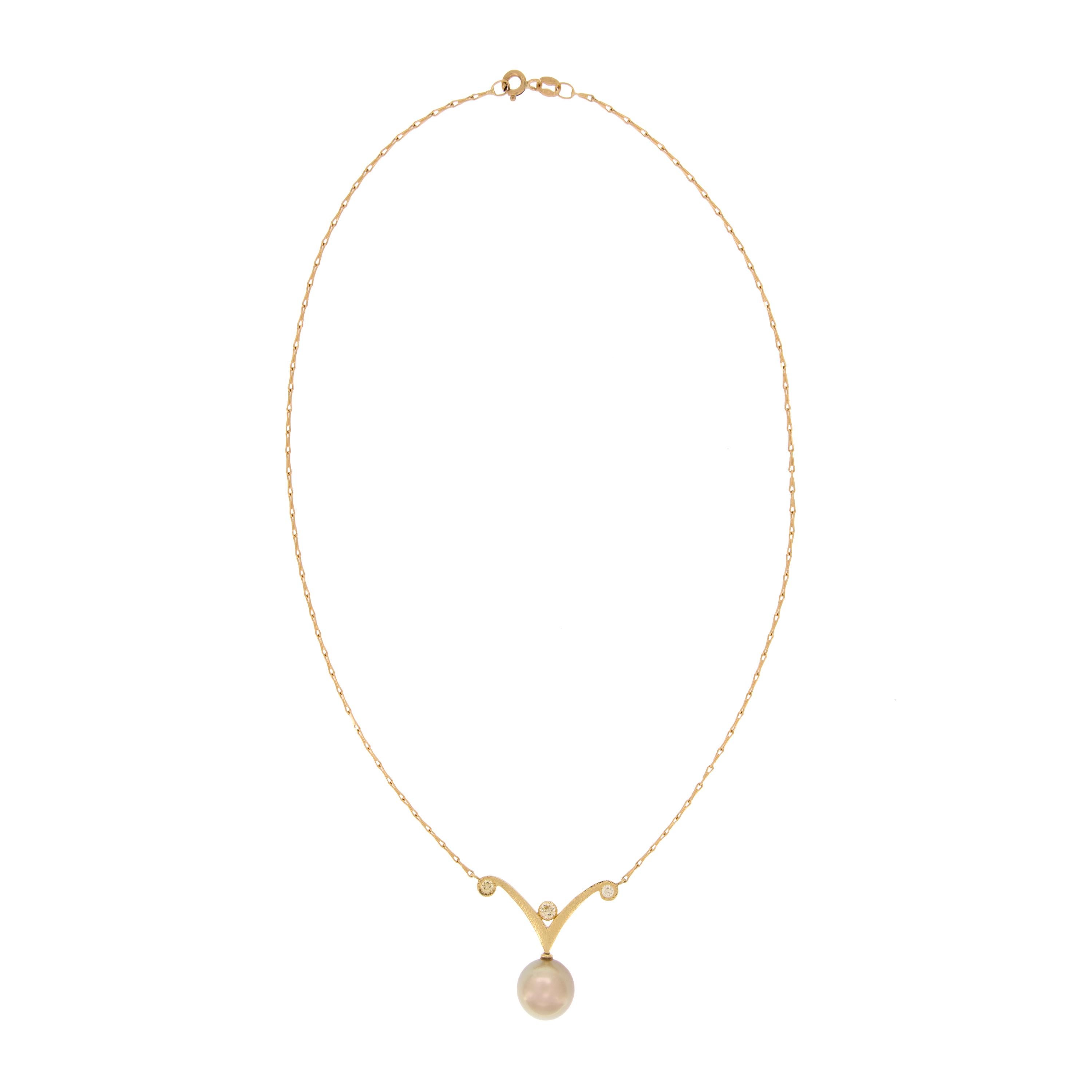 Le collier de perles et de diamants, de conception simple et en forme de rouleau, est composé d'une perle dorée de 11,3 mm aux reflets roses et est suspendu à une chaîne barleycorn de 16 pouces en or jaune 18k. Le pendentif mesure 1,25