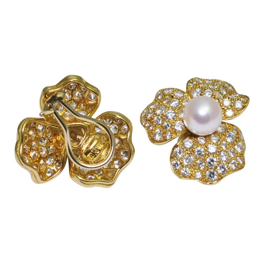 Bold and dramatic diamond and pearl 18ct gold flower ear clips, for non-pierced ears; these gorgeous earrings are in the form of stylised flowers, each with 3 undulating petals set with brilliant cut diamonds and a central cultured pearl.  The