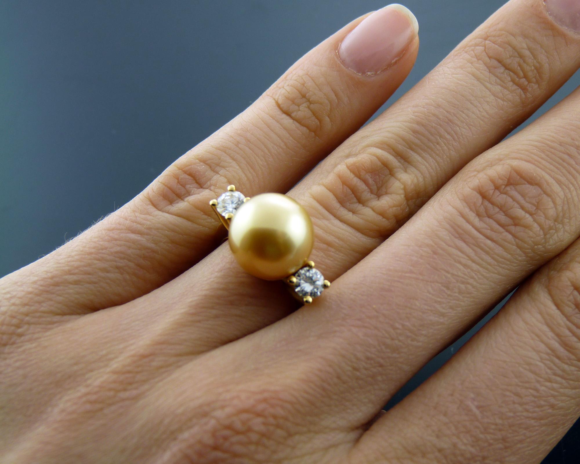 This exquisite cocktail ring is a true statement piece, featuring a lustrous 10.5 mm round pearl at its center. Surrounding the pearl are two sparkling round diamonds, totaling approximately 0.50 carats, adding a touch of brilliance and elegance.