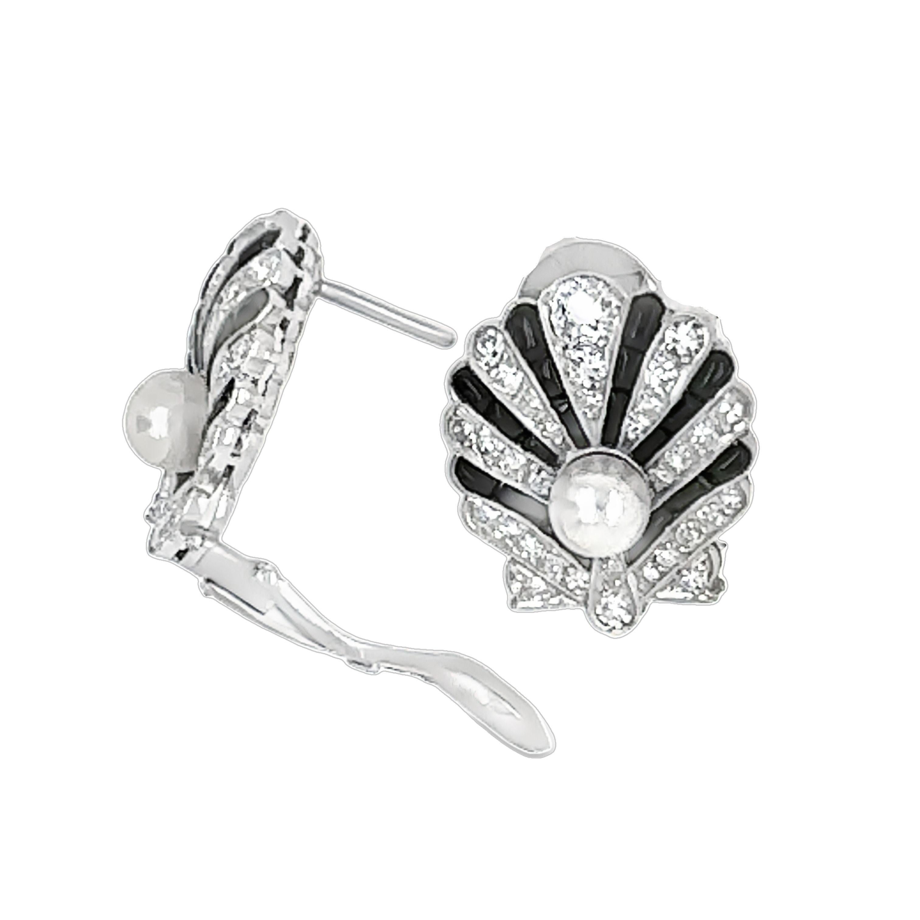 Step into the elegance of the Art Deco era with these stunning shell design pearl, onyx, and diamond earrings. Expertly crafted, these exquisite earrings epitomize the bold geometric lines and luxurious materials characteristic of the period. Each
