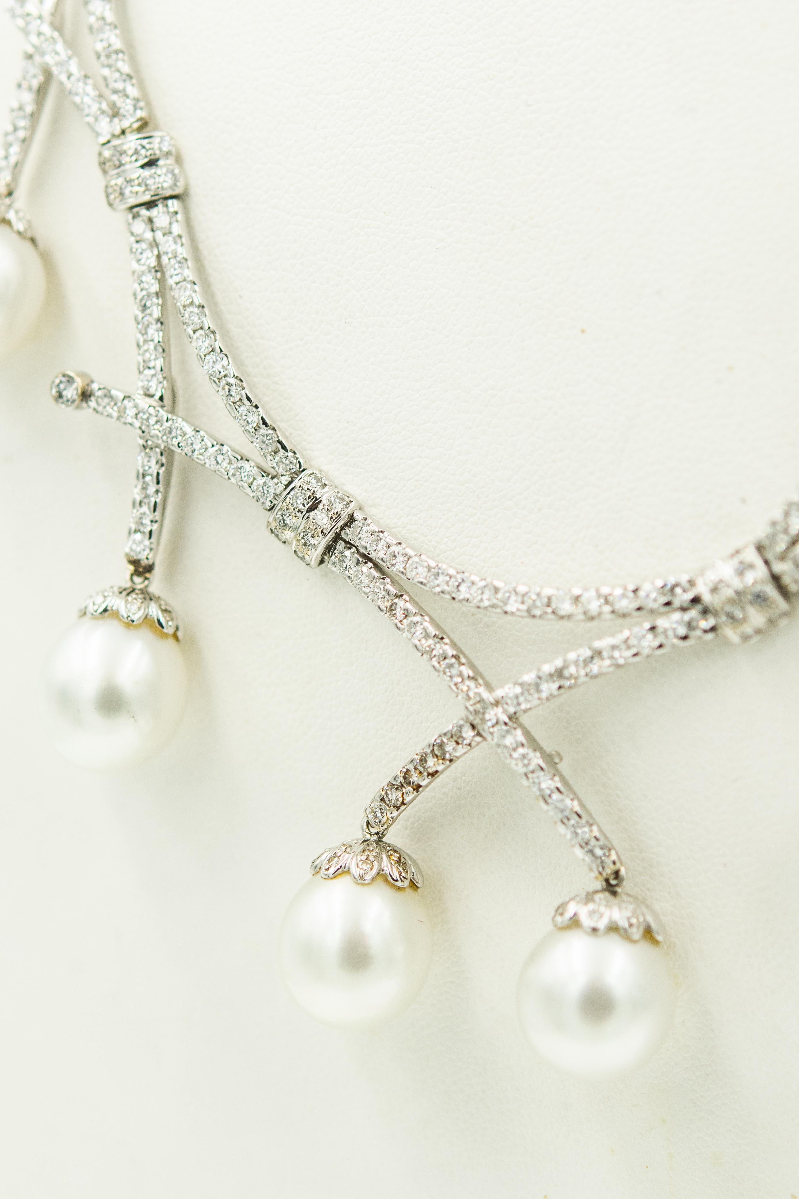 Atemberaubende Halskette im Latz-Stil mit 7 Barockperlen (ca. 11,50 mm), die eine feine silbrig-weiße Farbe und guten Glanz haben und an einer runden und bogenförmigen Halskette hängen.  Die siebenteilige Vorderseite hat sowohl runde als auch